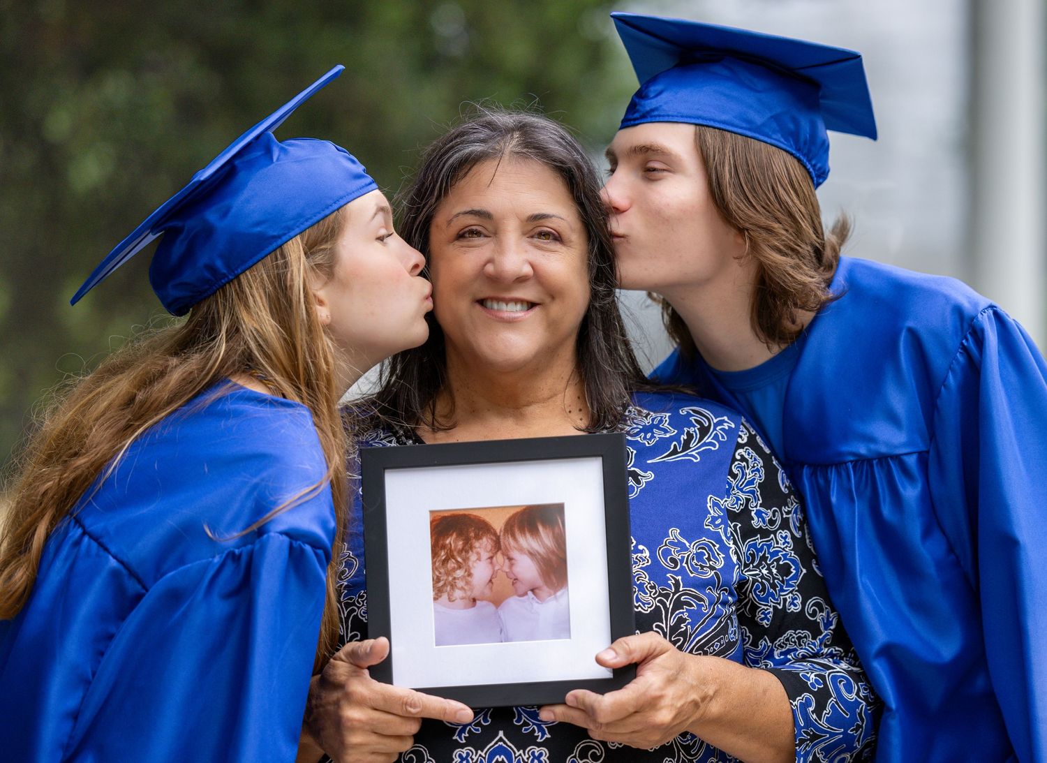 Graduates in royal blue caps and gowns gather together during commencement ceremony celebrations.