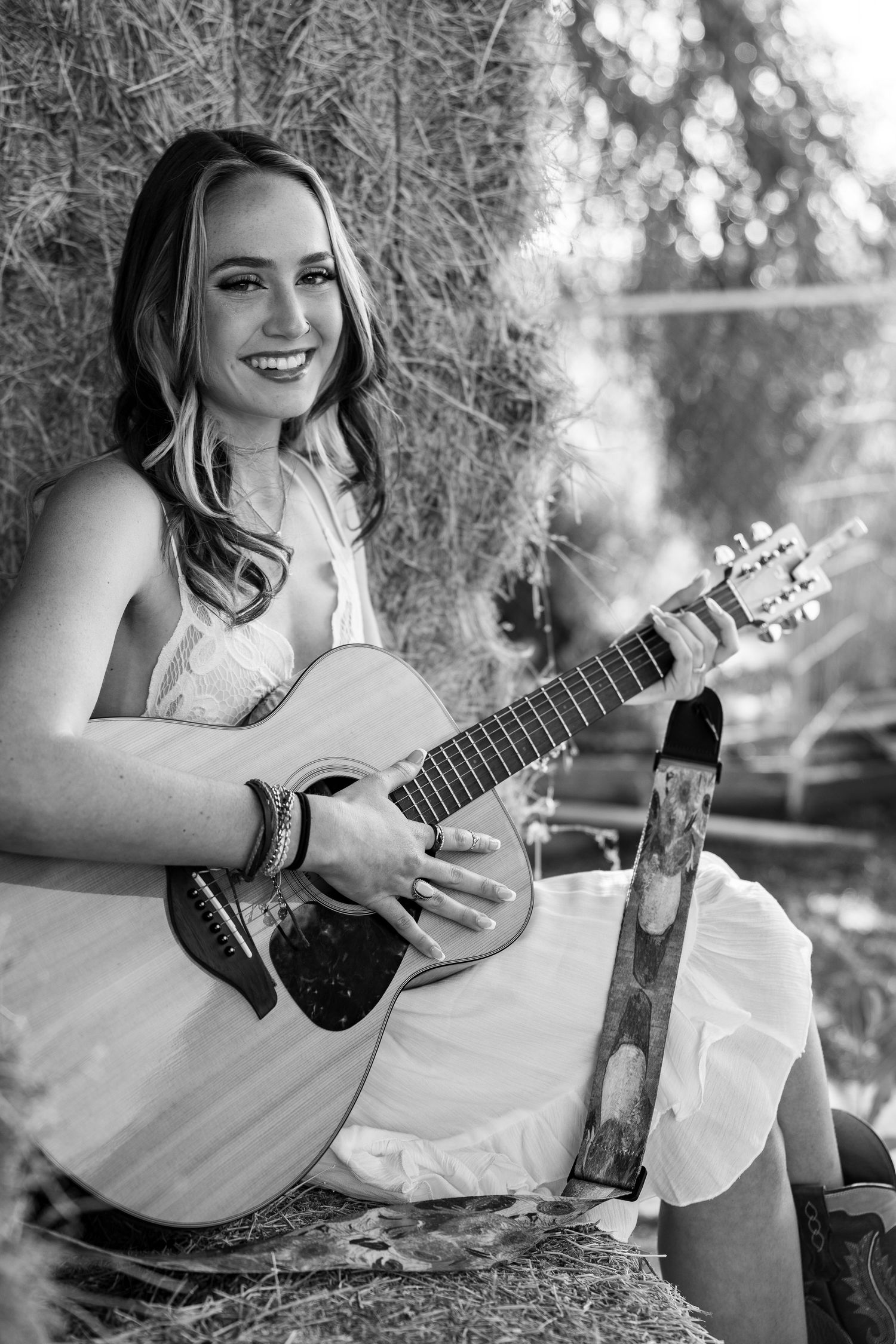 A black and white photo series showing someone playing a ukulele while sitting outdoors in a natural setting.