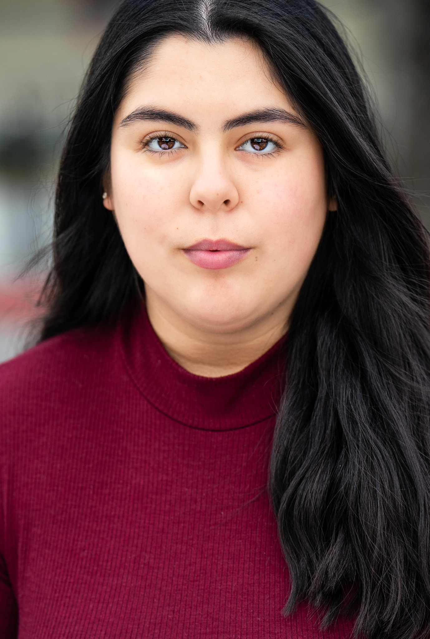theatrical headshot. series in burgundy turtleneck showing various expressions against dark background.