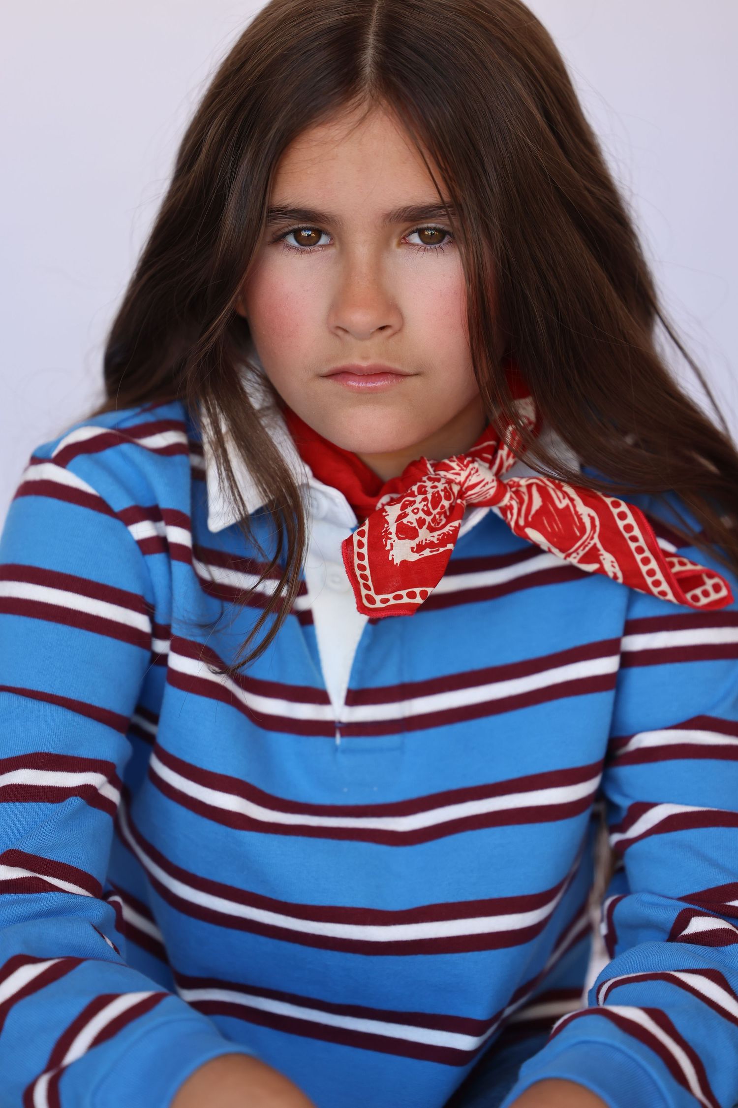 Striped blue and red sweater with bandana styled as neck accessory.