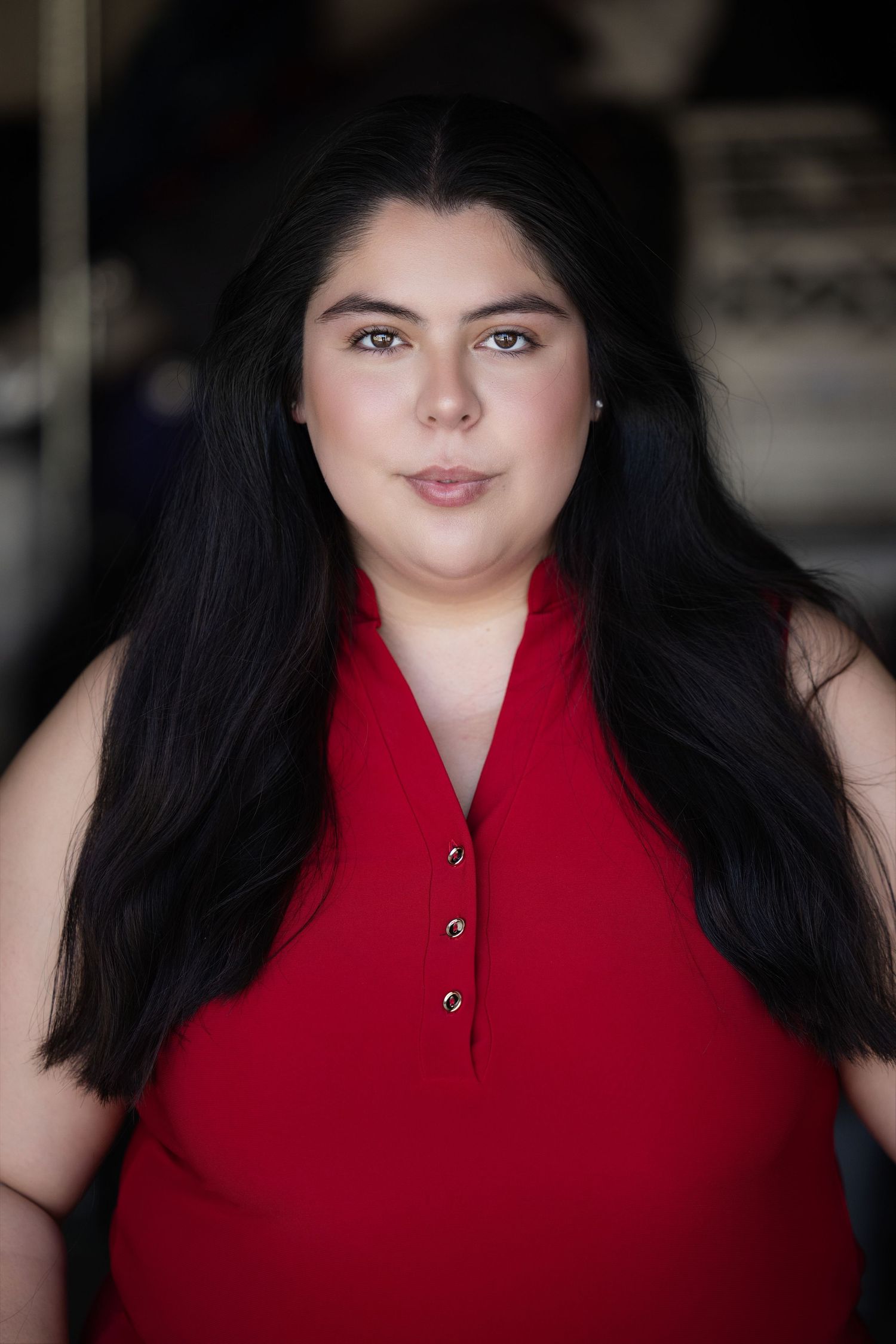 vertical series headshot. Portrait series in red sleeveless top with dark hair and natural makeup.