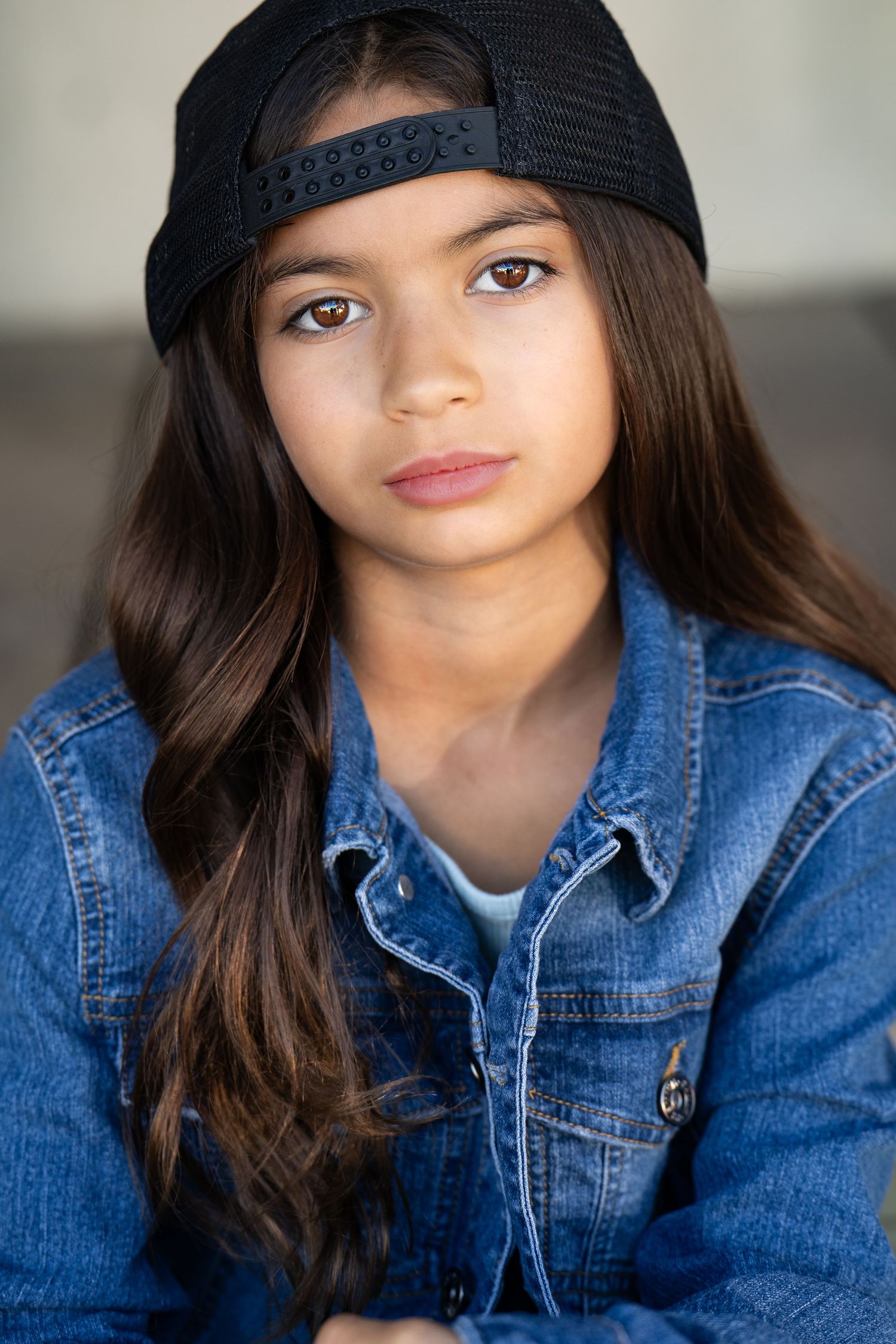 tomboy headshot series showcasing young model in denim jacket and black cap.
