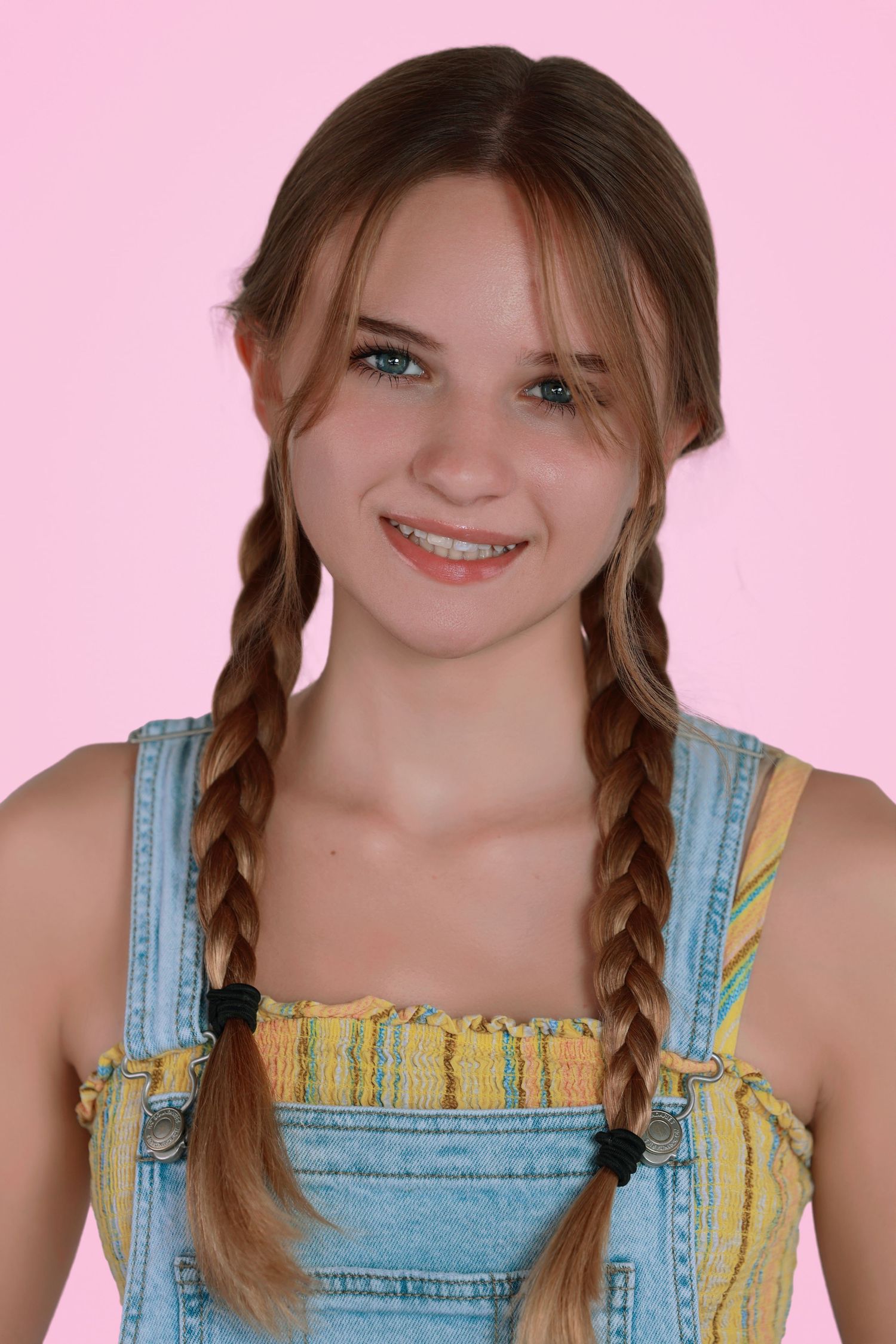 Person wearing denim overalls and a bright smile in a portrait collage series against a pink background.