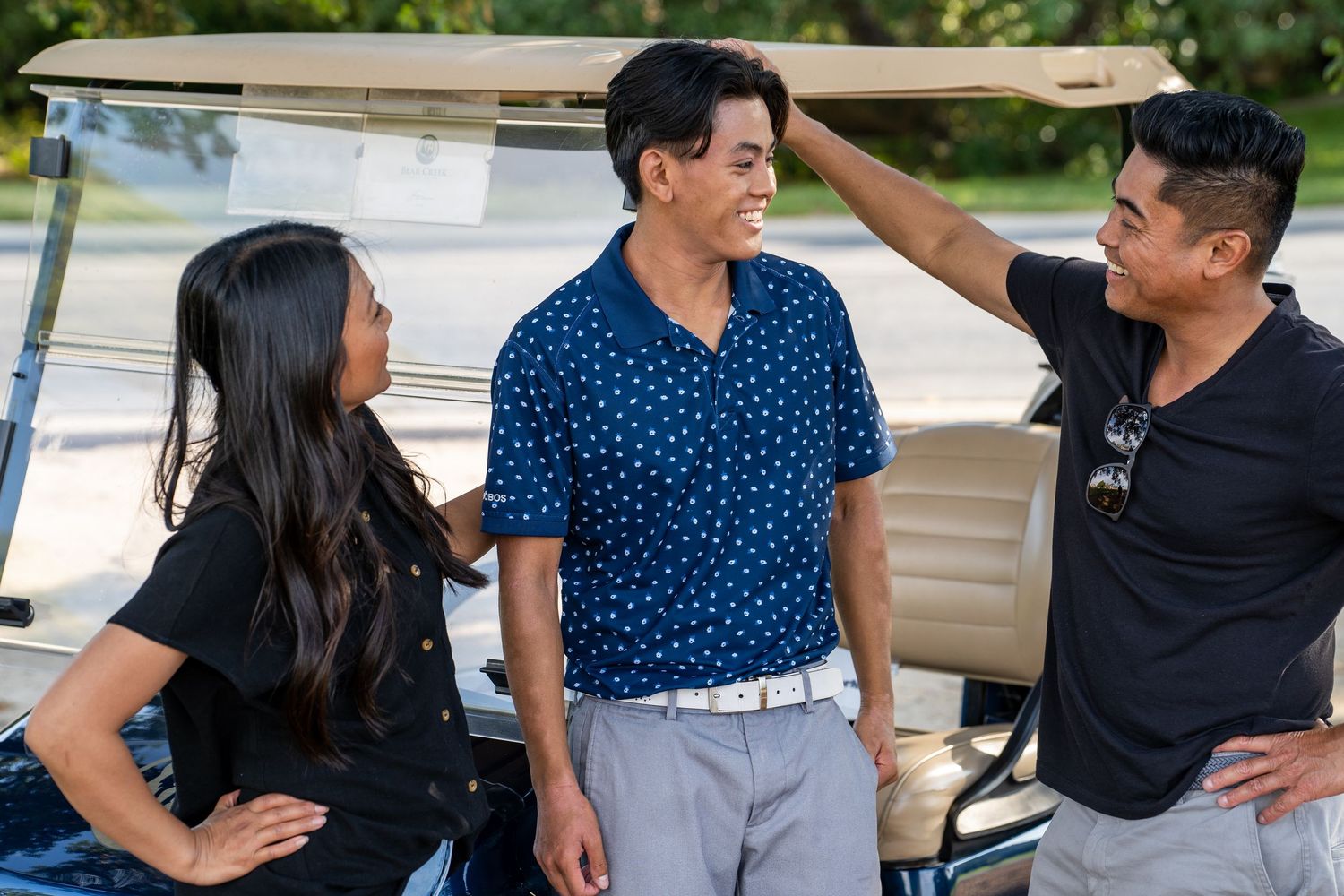 Group of people wearing navy blue and black outfits having a casual conversation outdoors.