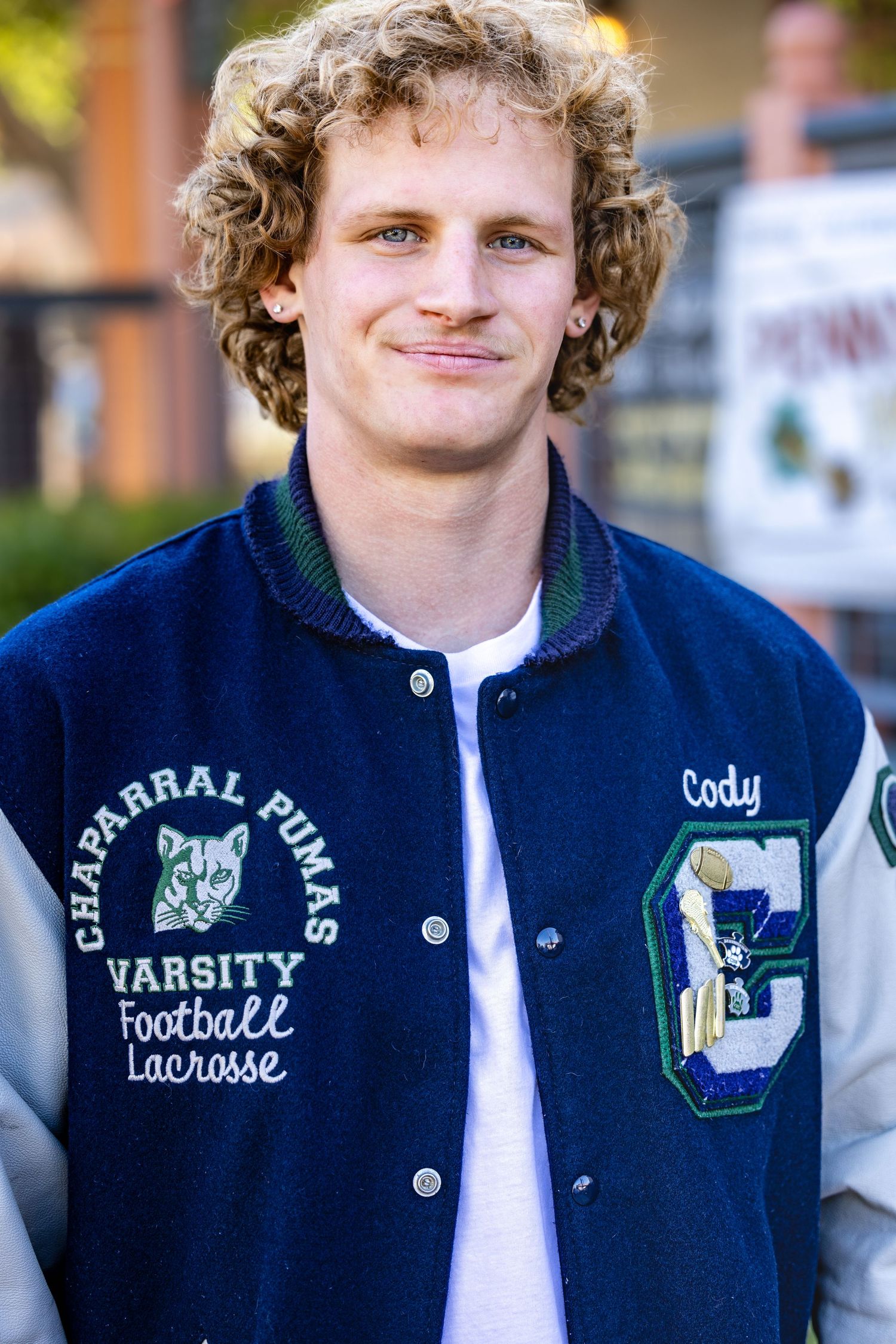 Navy blue varsity letterman jacket with white trim and athletic patches shown in multiple views.