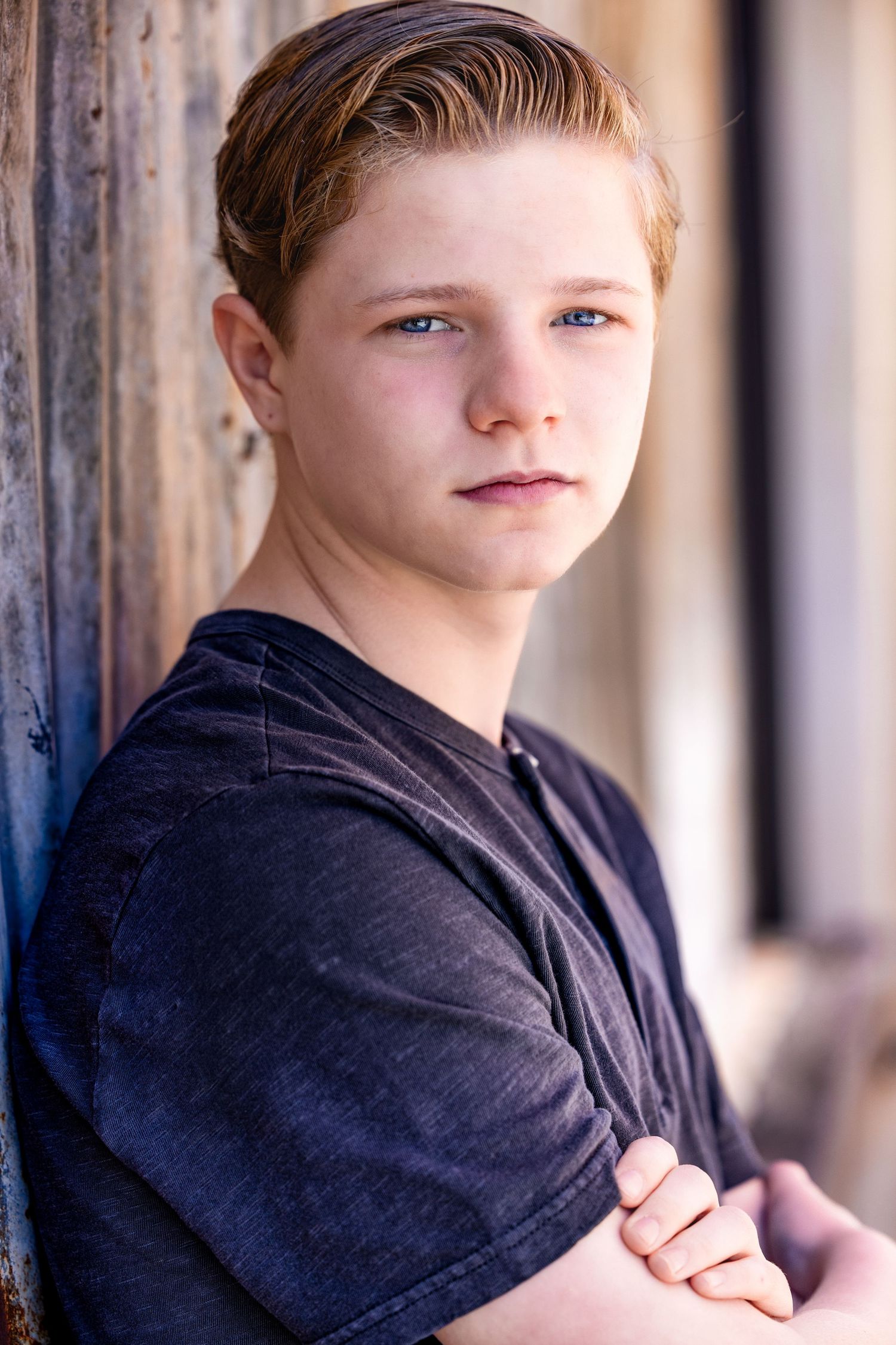 Side profile headshots of youth in dark shirt against wooden background.
