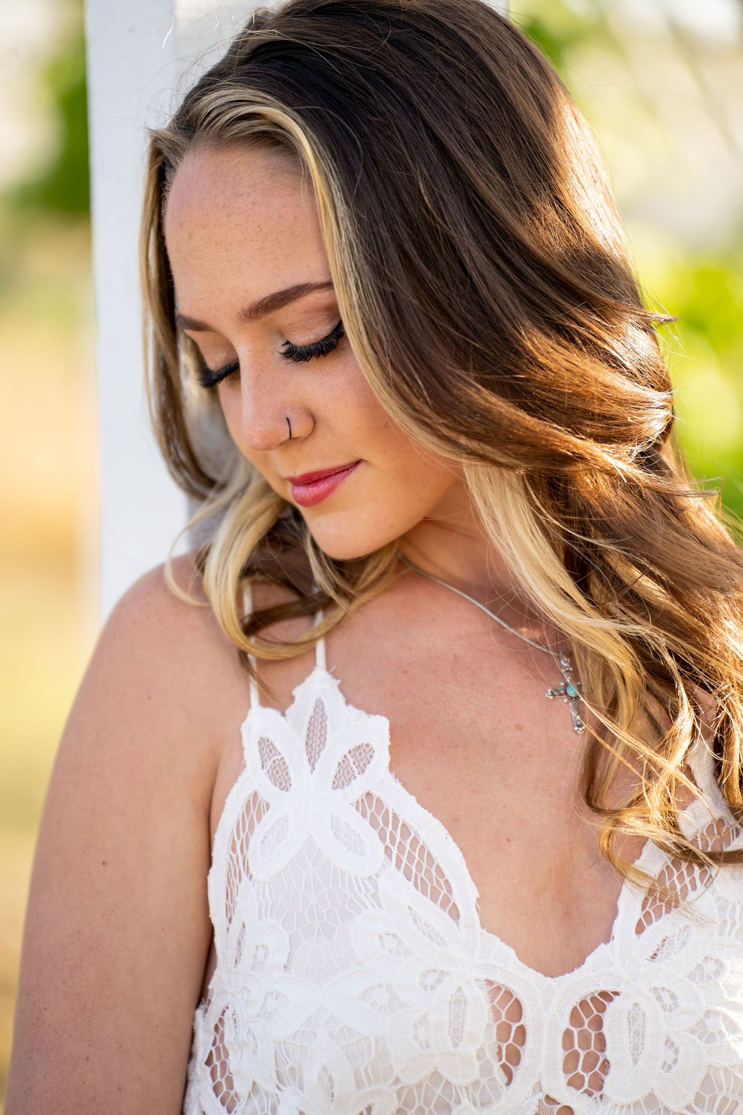 Close up portrait showing delicate white lace details and soft sunlit hair in romantic outdoor lighting.