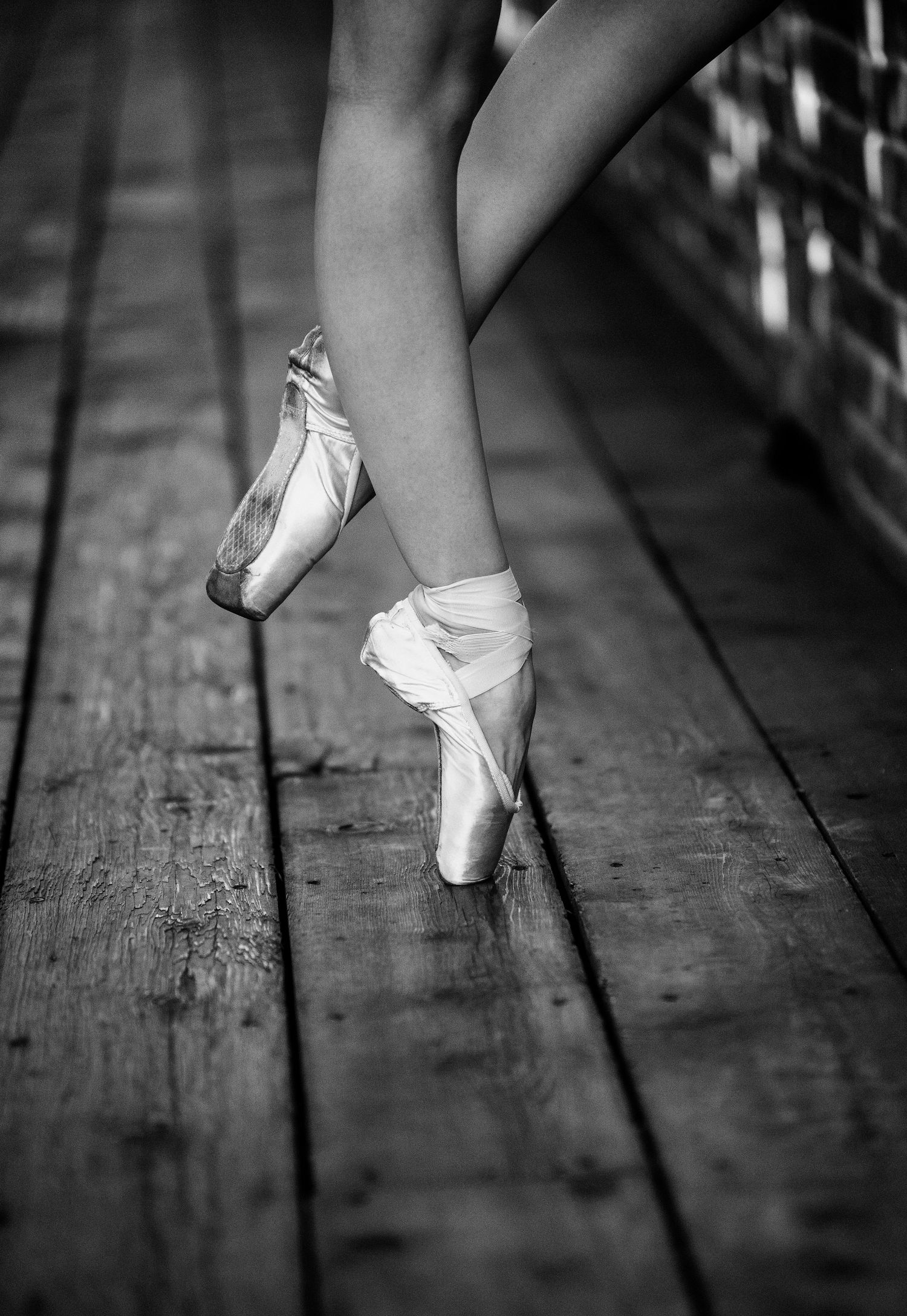 A series of black and white photos showing ballet pointe shoes in different positions on a wooden floor.