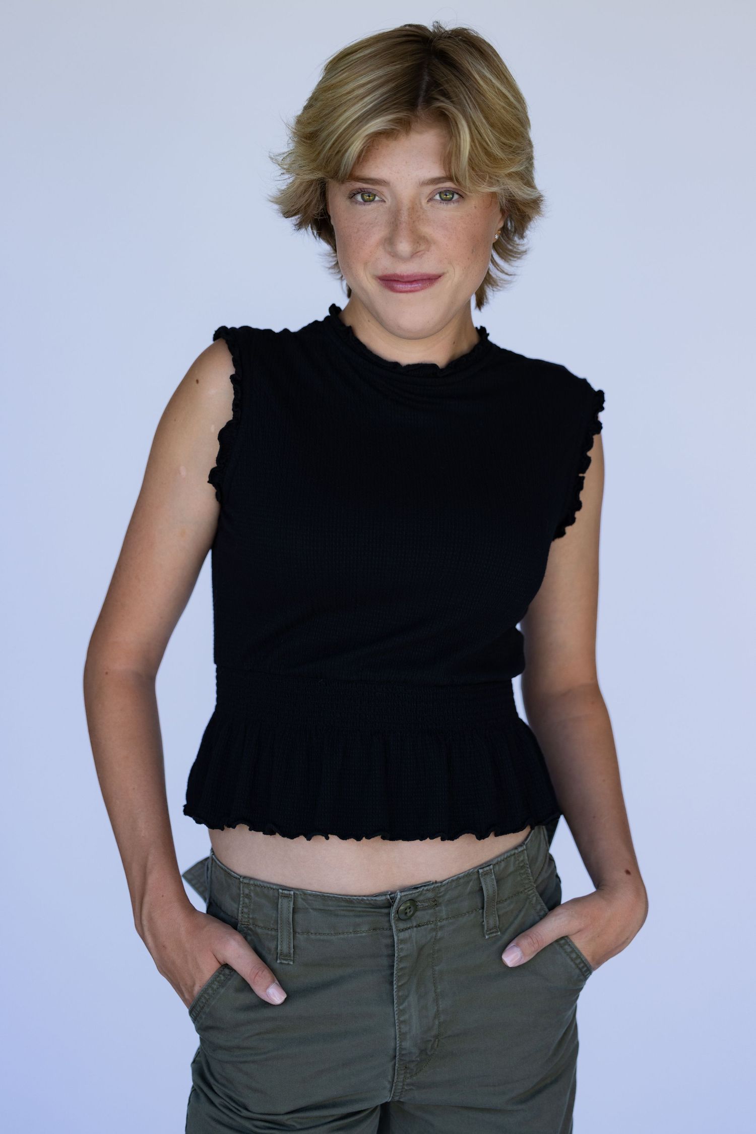modeling package. Fashion poses in black crop top and olive pants against white background.