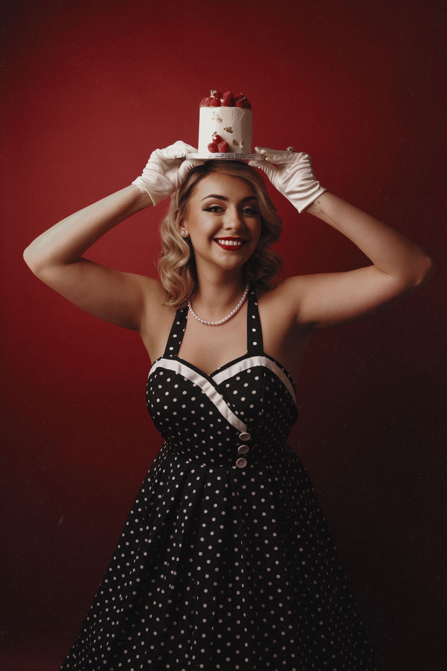 Retro-styled photo featuring a polka dot dress against a dark red background.