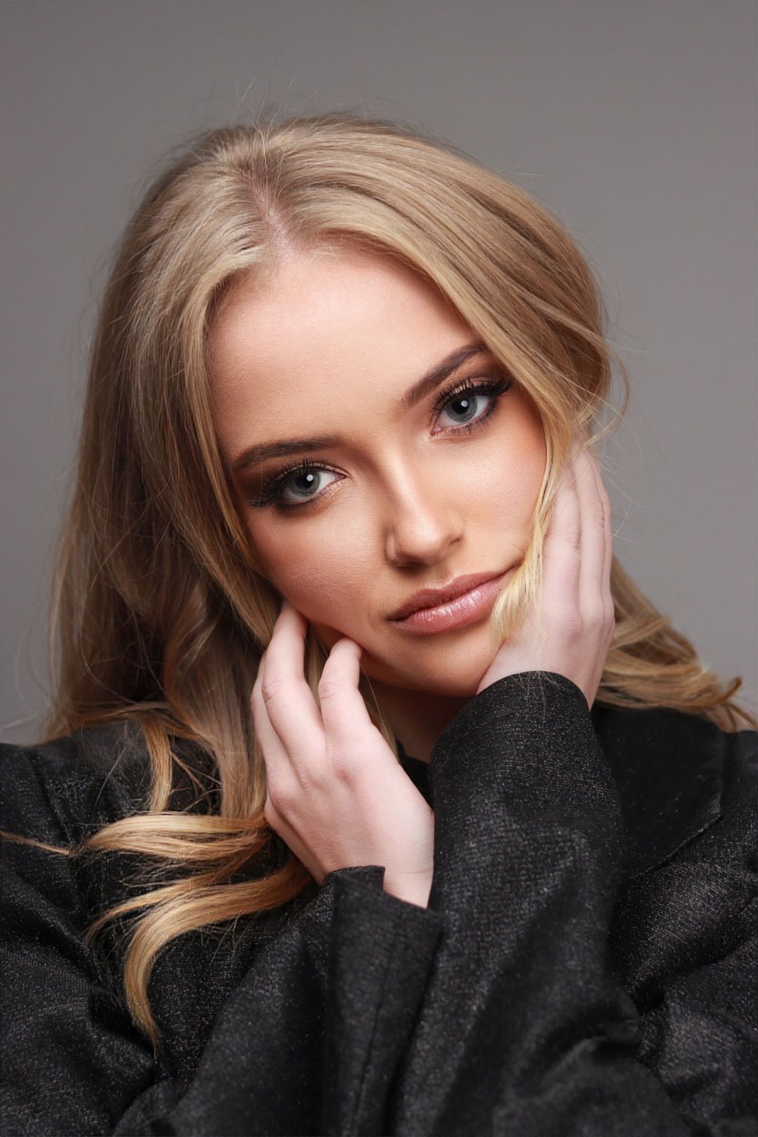 Professional beauty portraits featuring soft lighting and dark sweater against grey background.