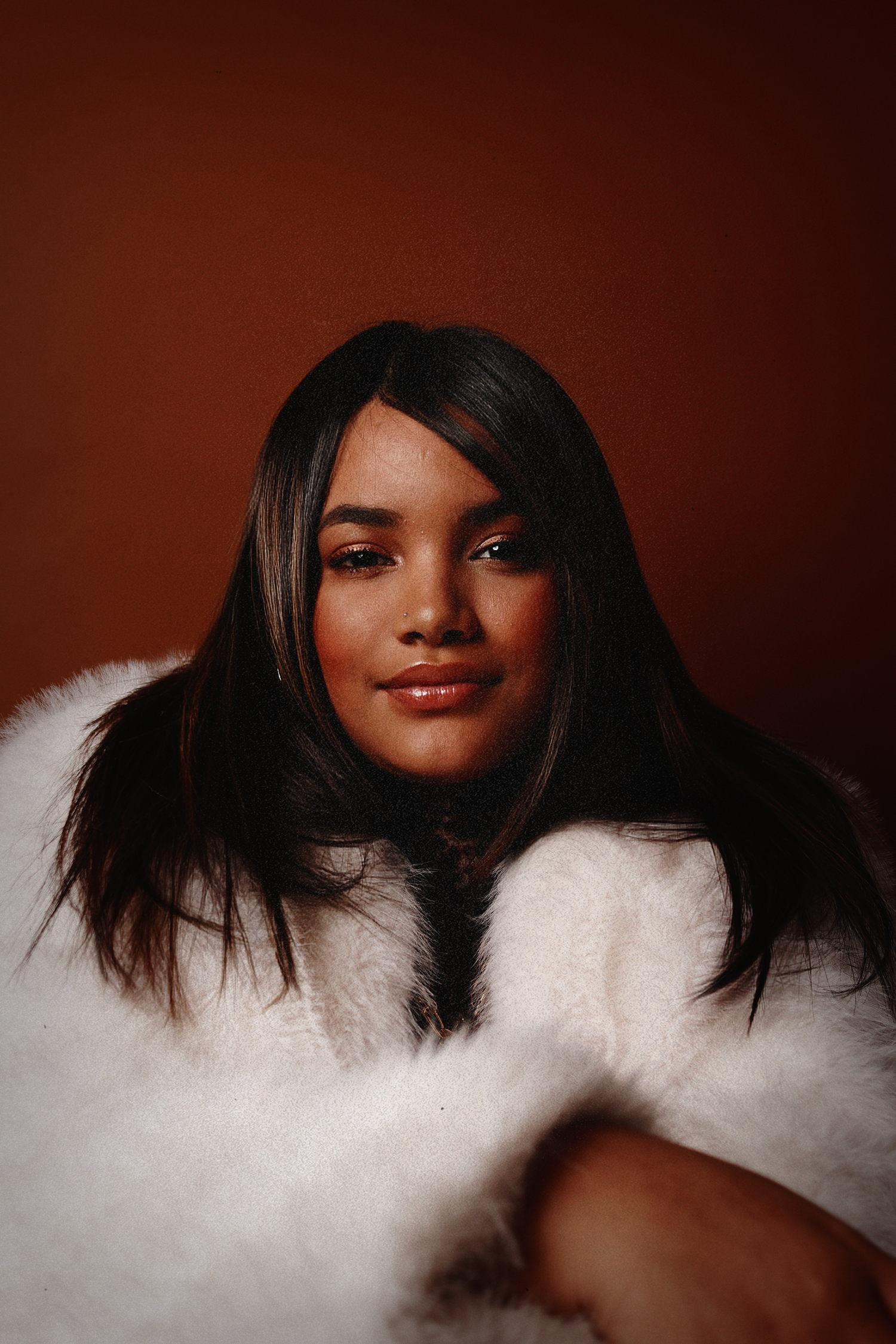 Portrait series with white fur coat against deep burgundy background creating contrast.