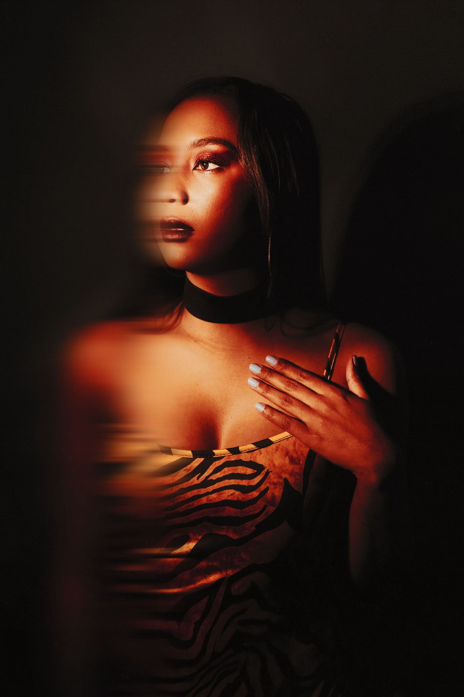 Artistic portrait using red lighting and shadow effects to create a mysterious mood.