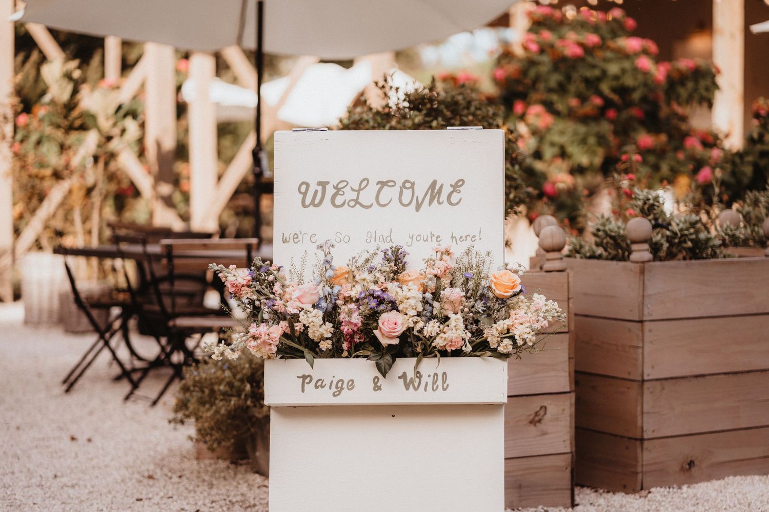 Elegant wedding welcome sign adorned with pink and white flowers for Paige and Will.