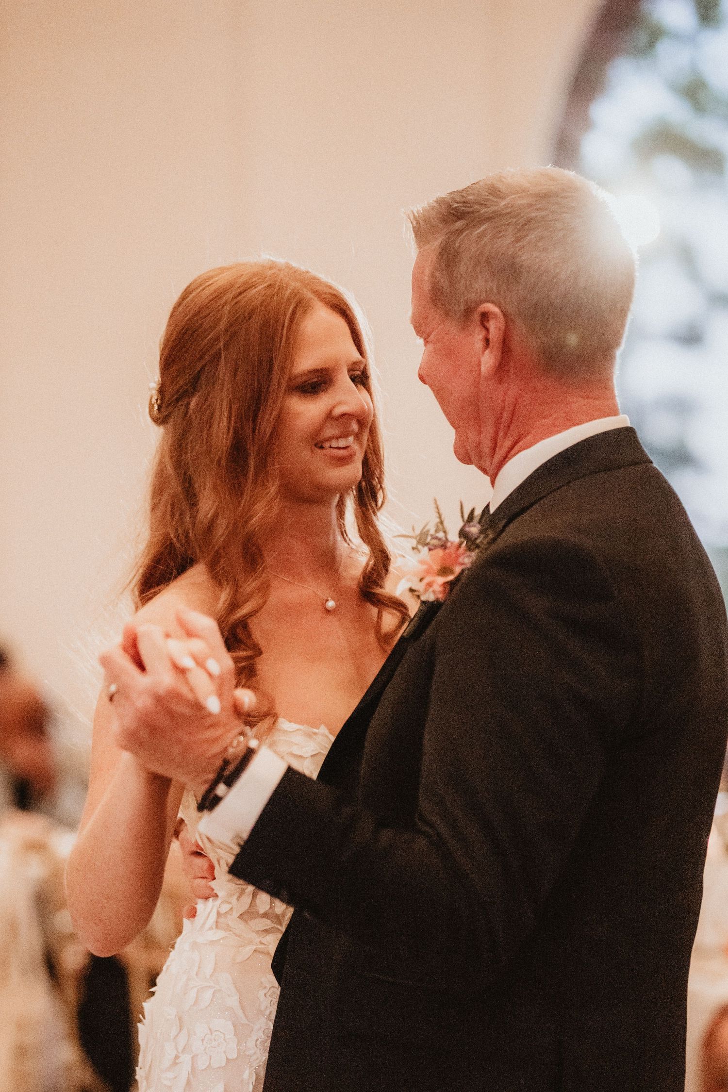 Bride shares a happy father-daughter dance at her wedding reception.