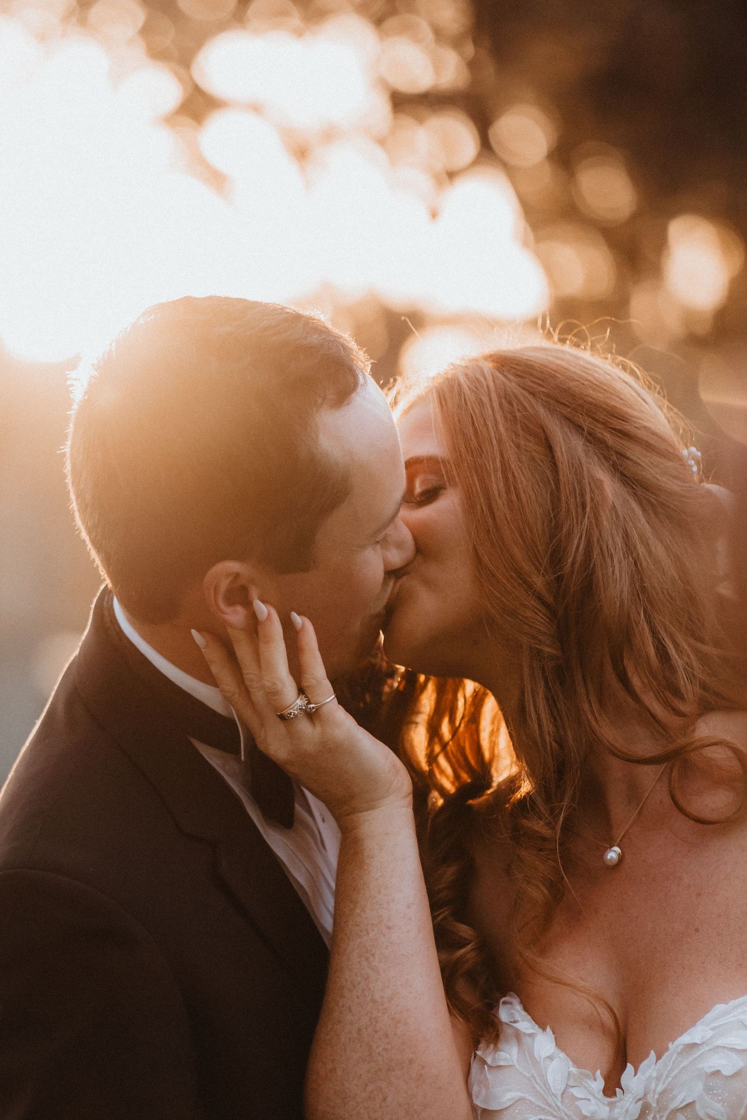 Bride and groom share a romantic golden hour kiss on their wedding day.
