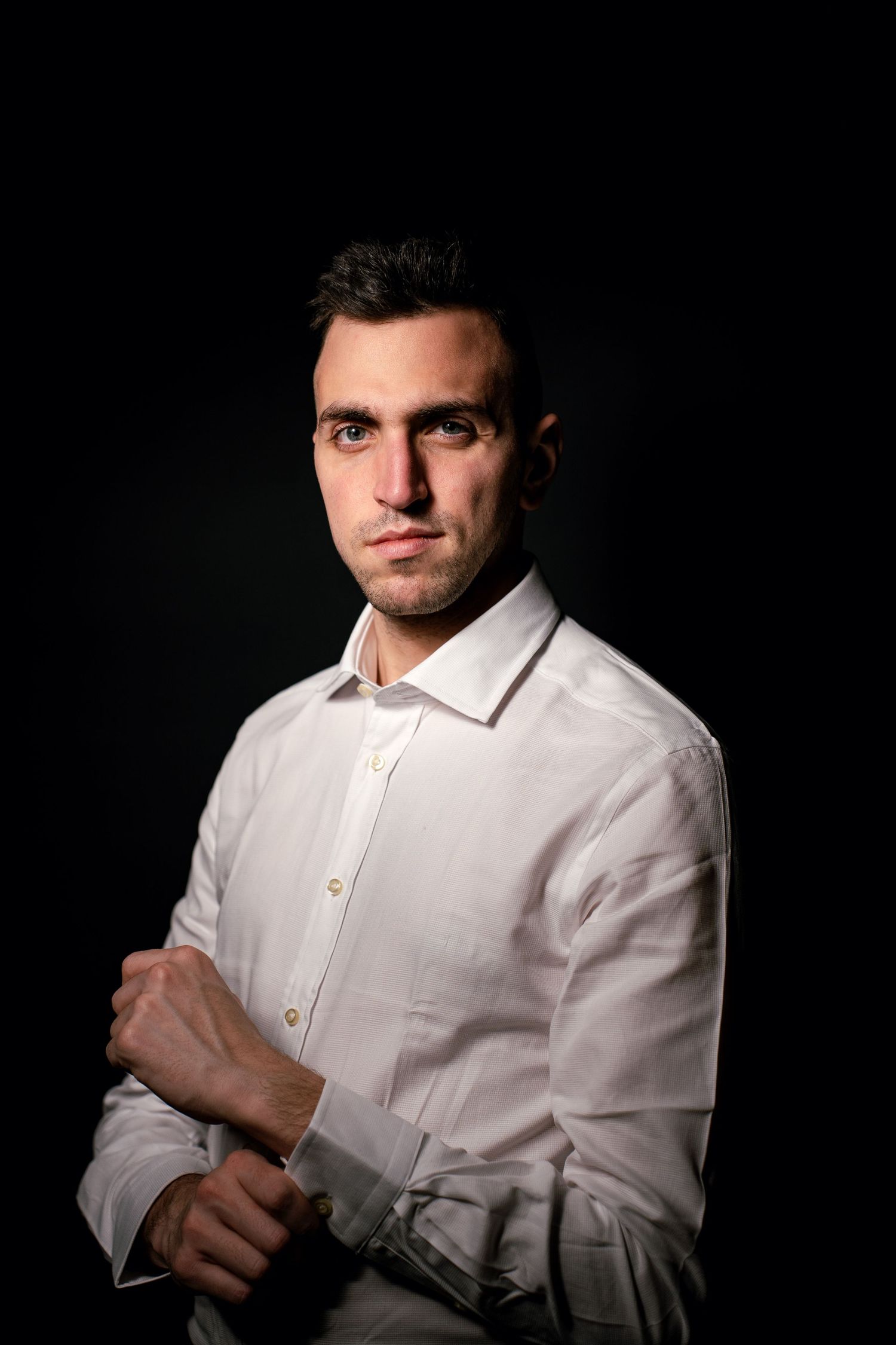 Portrait photographique artistique d’un homme en clair-obscur, ambiance sombre et regard expressif.