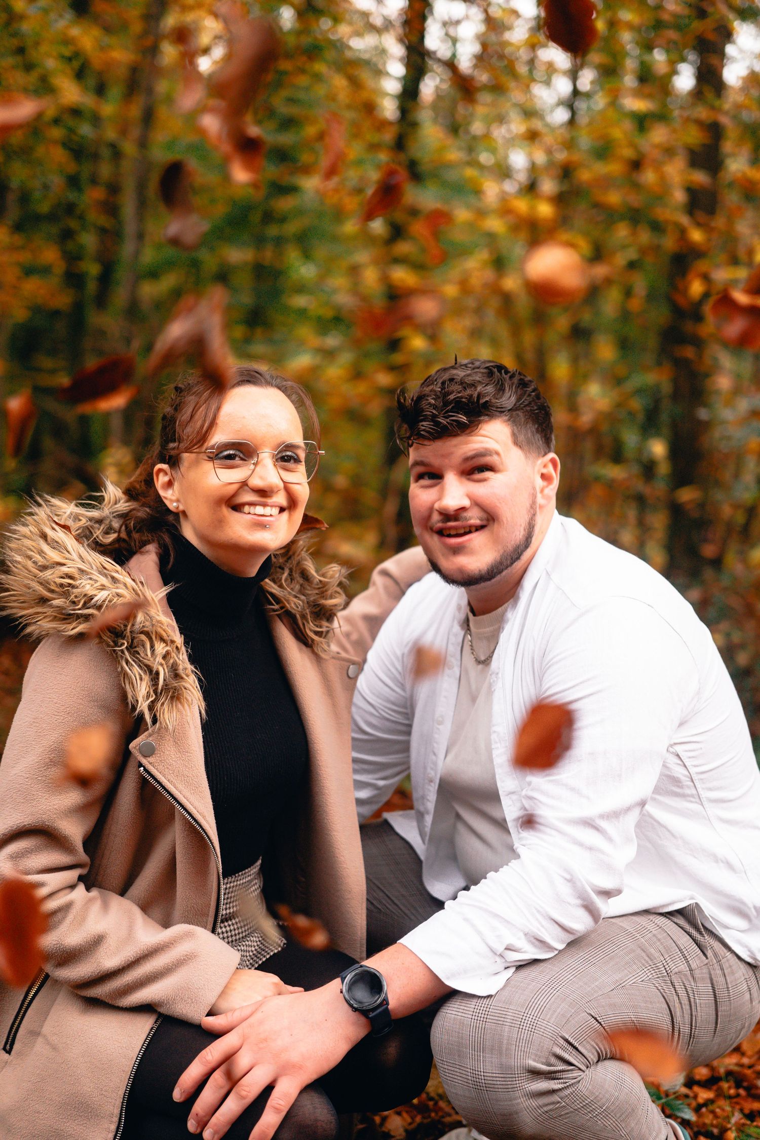 couple photo posant devant l'objectif pour la première fois garder un souvenir avec photographe professionnel automne et hiver, feuilles