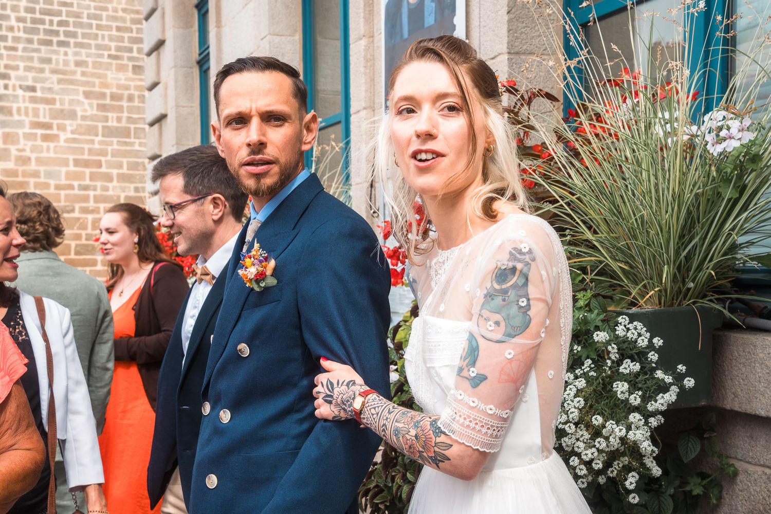 Photographie de mariage élégante capturant un couple de mariés s’embrassant à la sortie de l’église, lumière naturelle et émotion