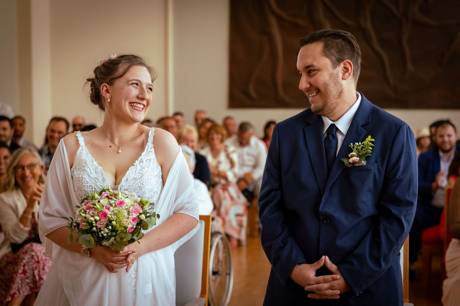 mariage, couple face à devant le maire tenant un bouquet de fleur à la main. se regardant en face e souriant aux éclats