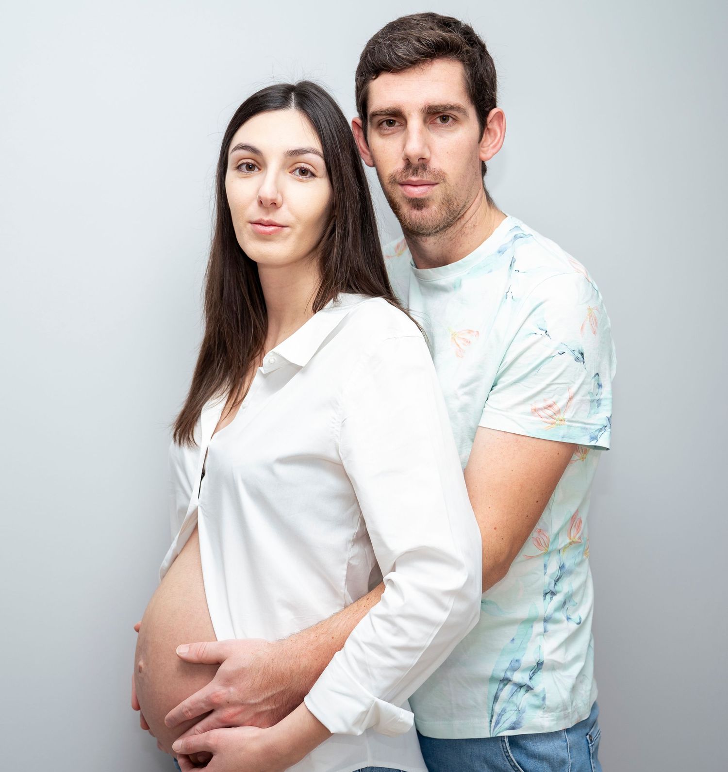 couple photo de grossesse posant devant l'objectif pour la première fois garder un souvenir avec photographe professionnel