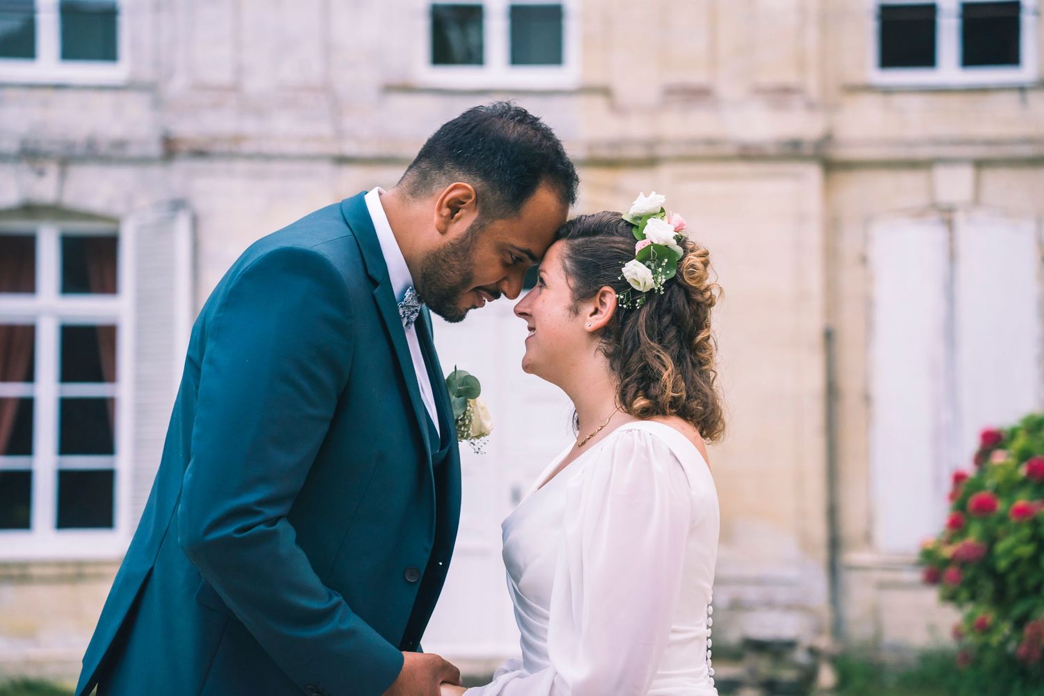 Photographe de mariage documentant un échange de regards entre les mariés lors de la cérémonie, ambiance intime et cinématographique.