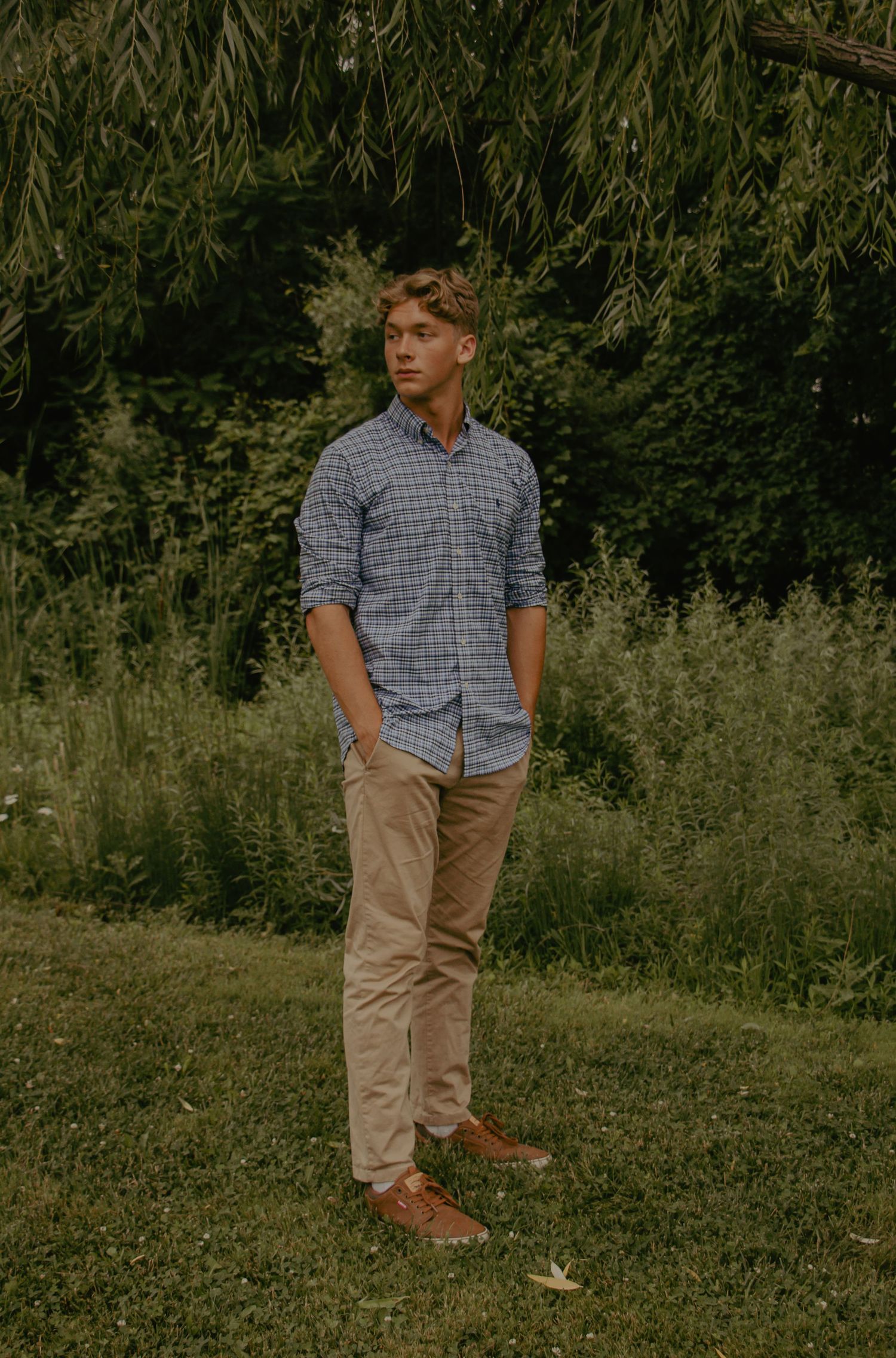 Person in casual attire standing in a grassy field.