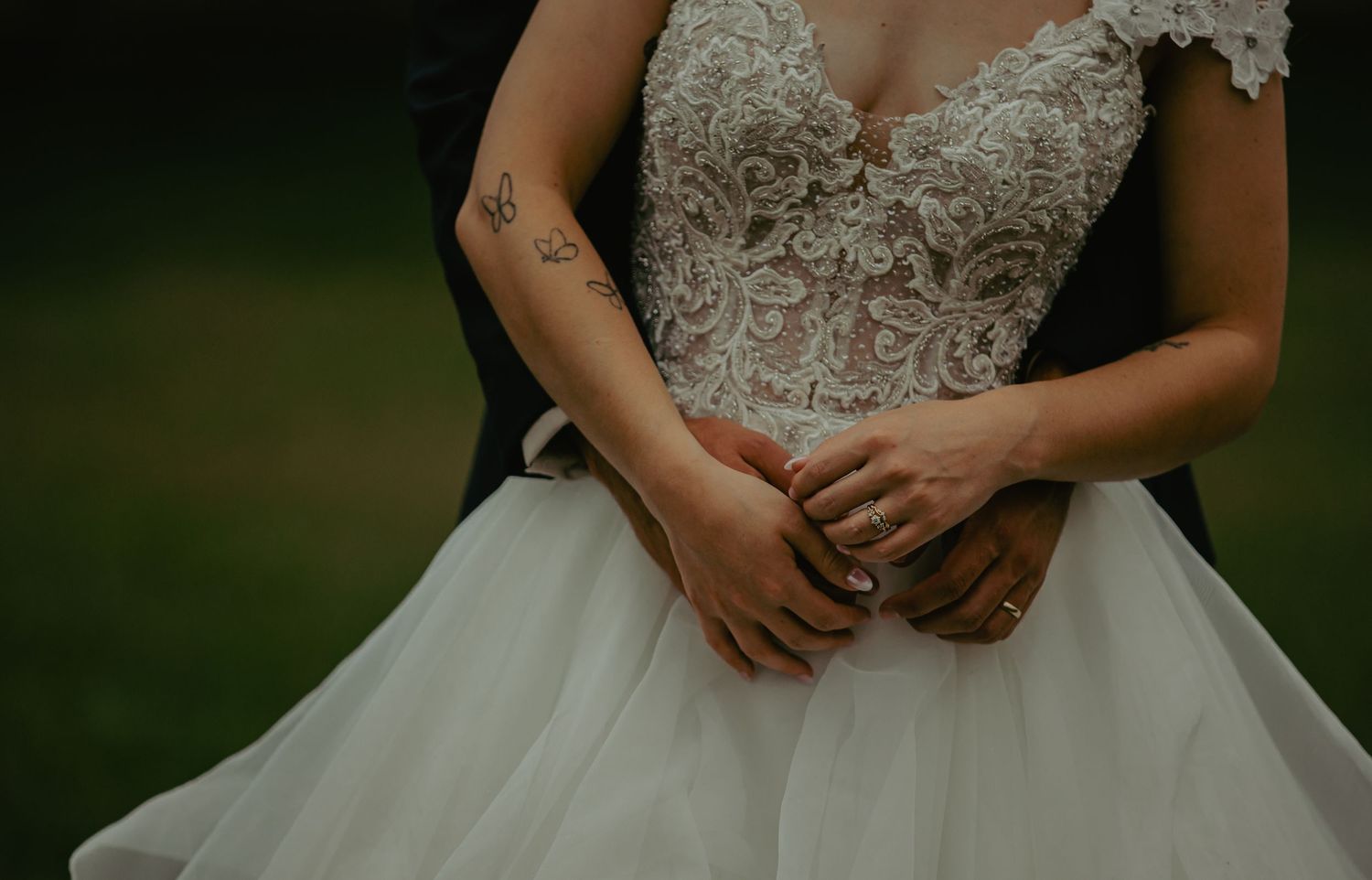 Close-up detail of lace bodice on white wedding gown with tulle skirt.