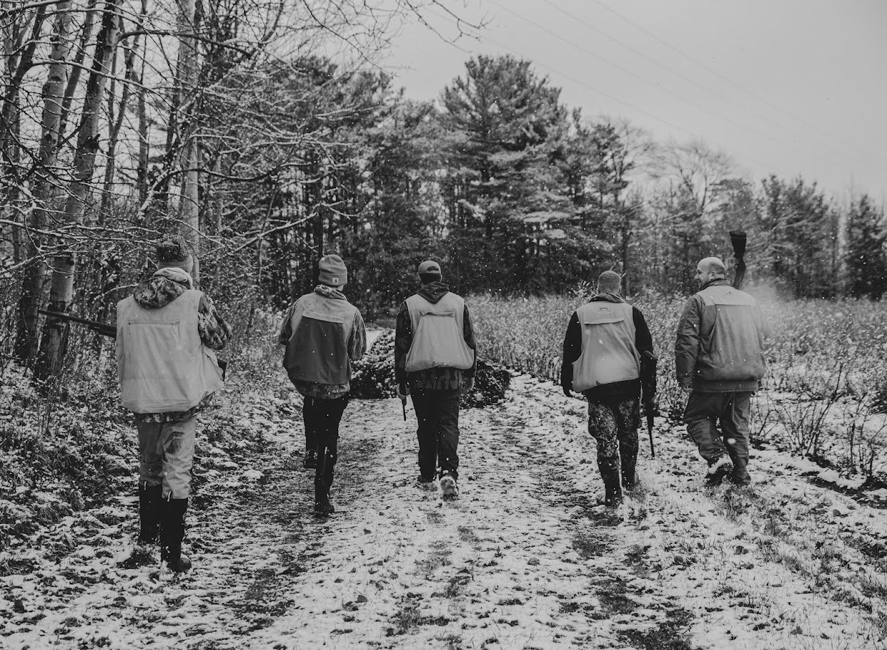 A group walking through a snowy forest path in winter.