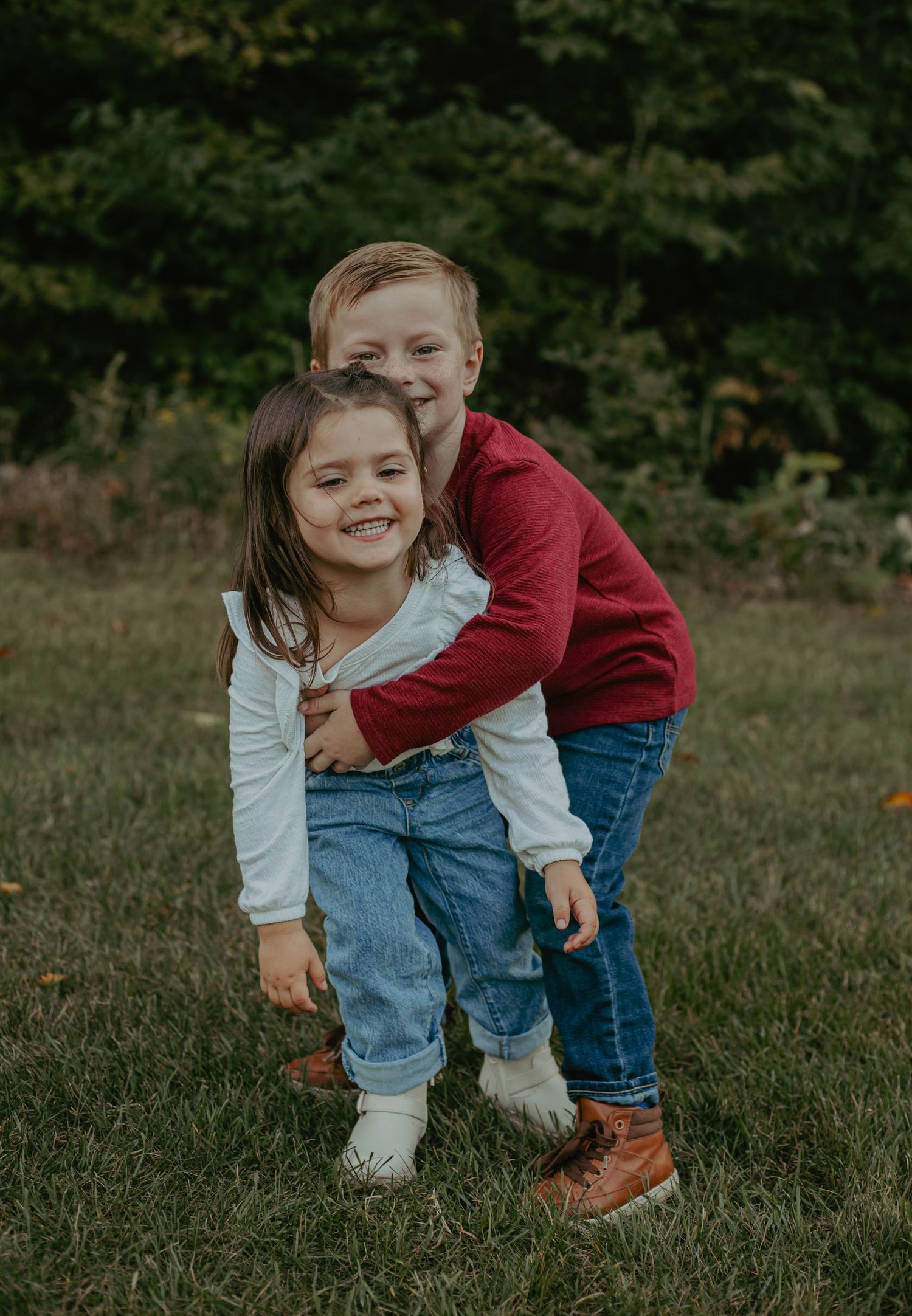 Candid playful moments captured in an outdoor grass field during golden hour.