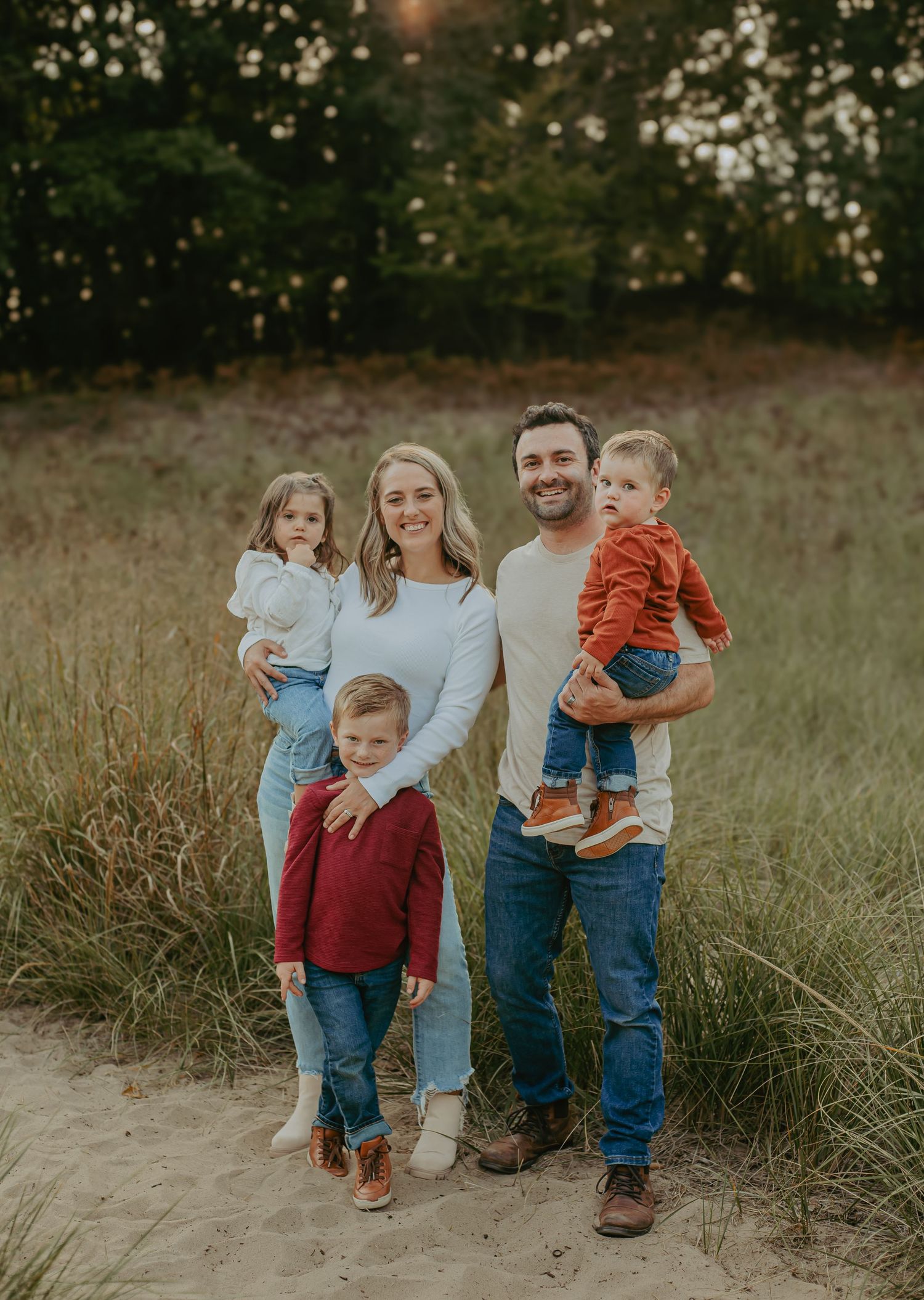 A family stands together on a nature trail during golden hour photography session.