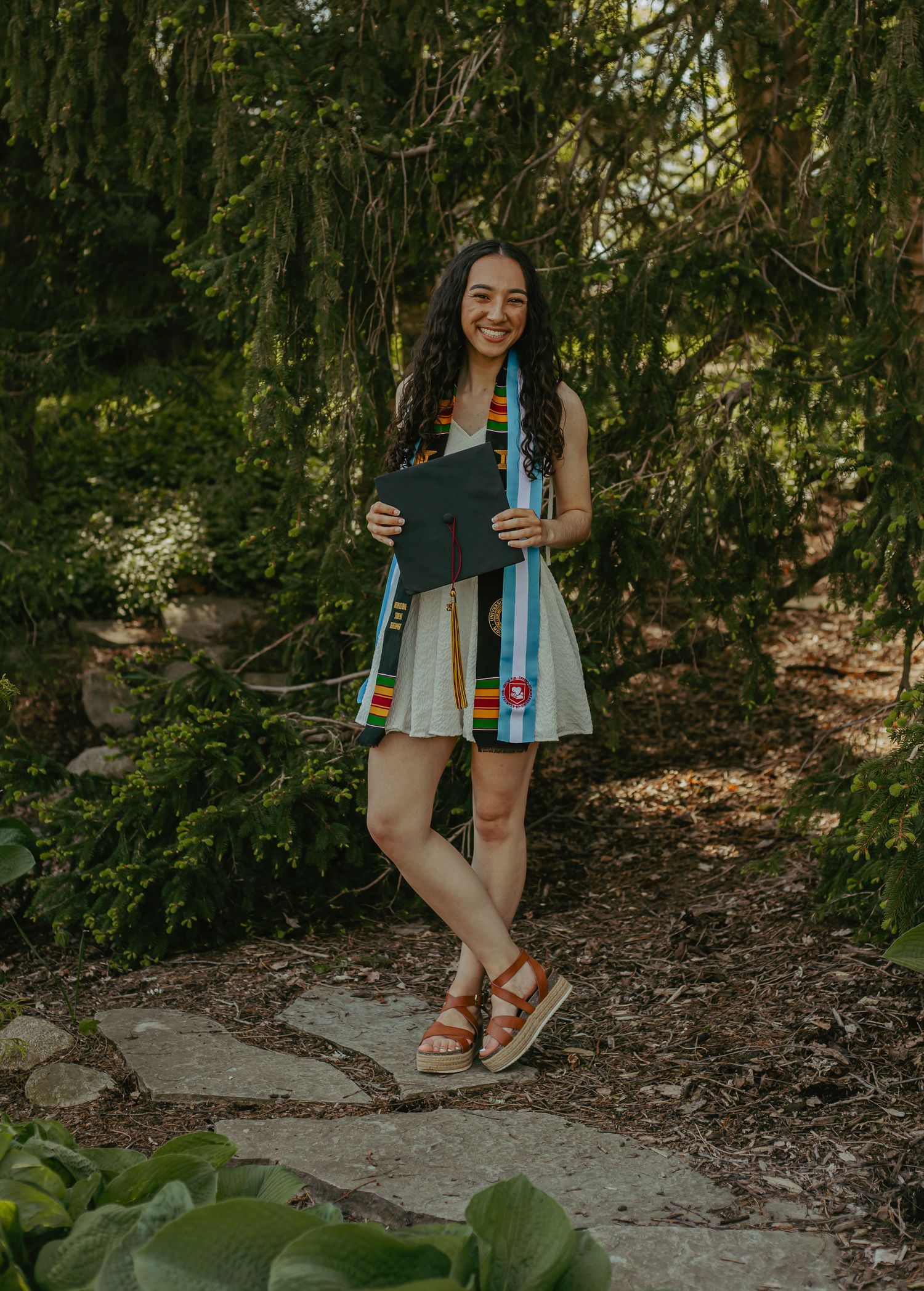 Casual summer outfit with sandals shown against a garden path.