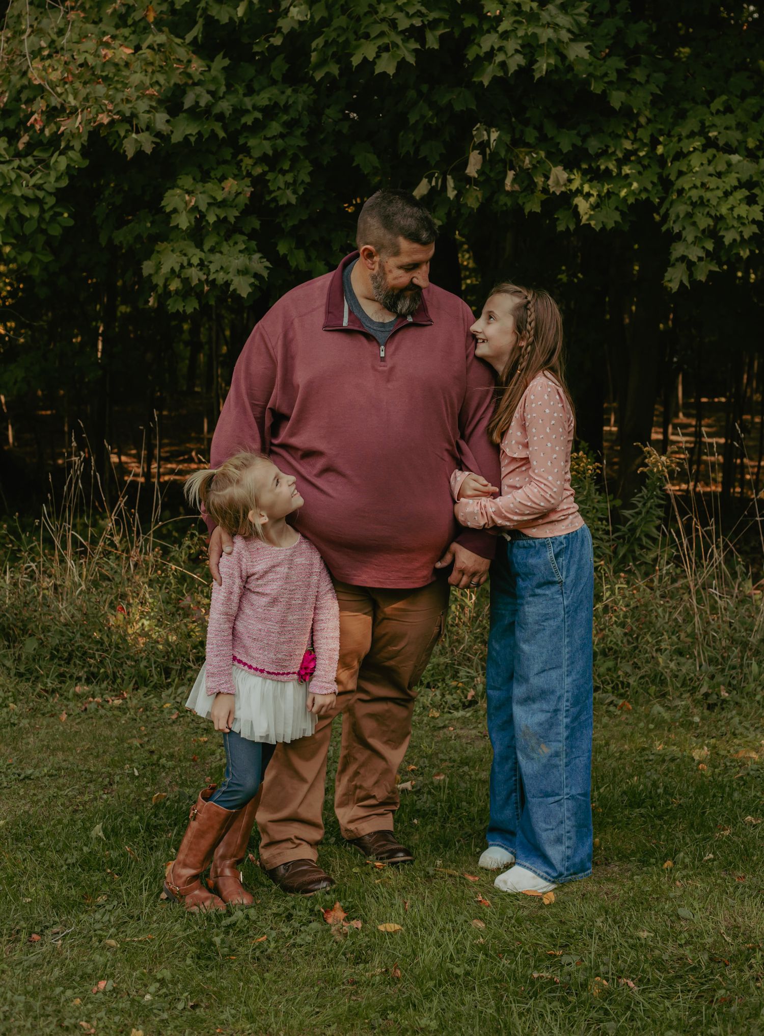 Family enjoying playful moments in a lush green field during summer.