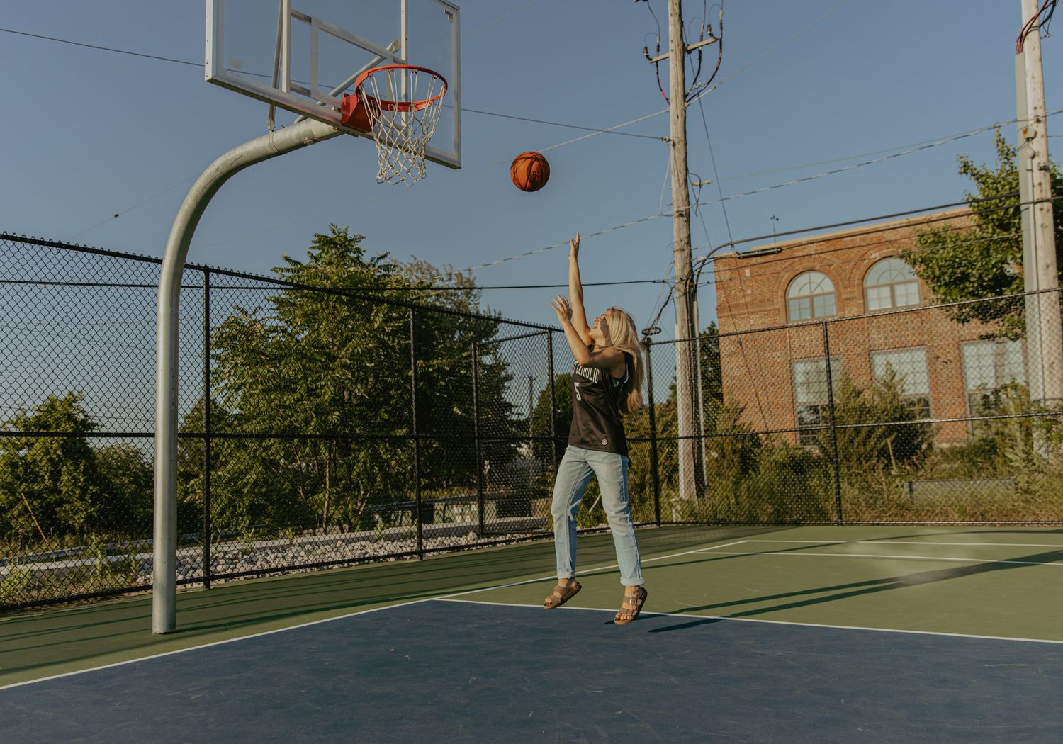 Basketball players competing on an outdoor court during a game.