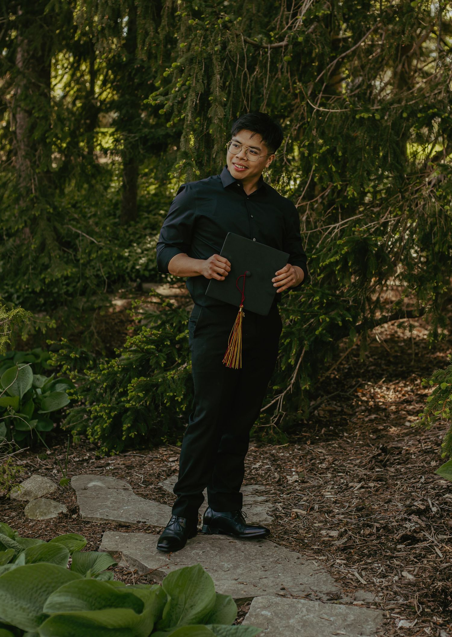 Dark formal attire photographed in a wooded garden setting.
