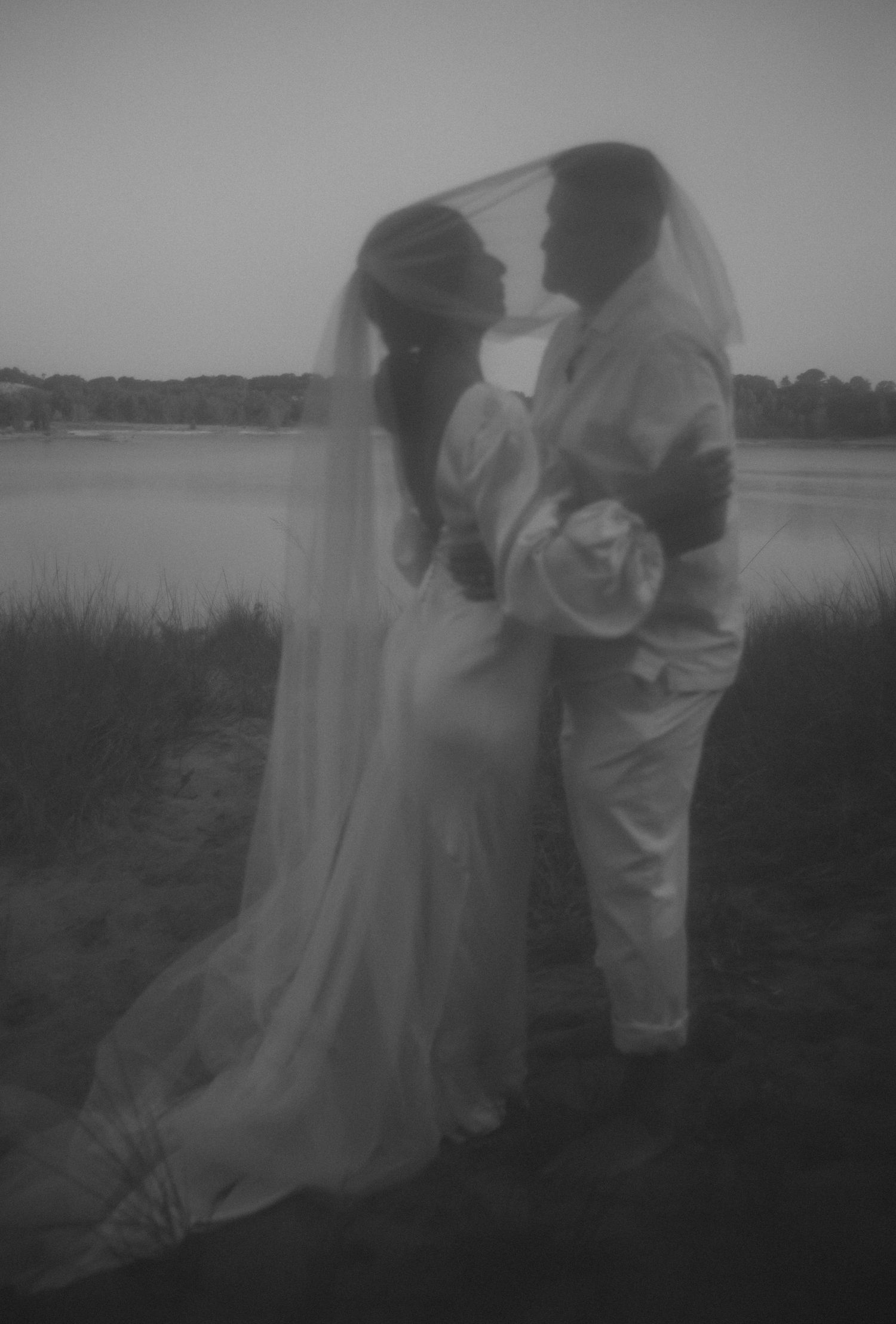 Dreamy black and white wedding portraits taken in a misty field.