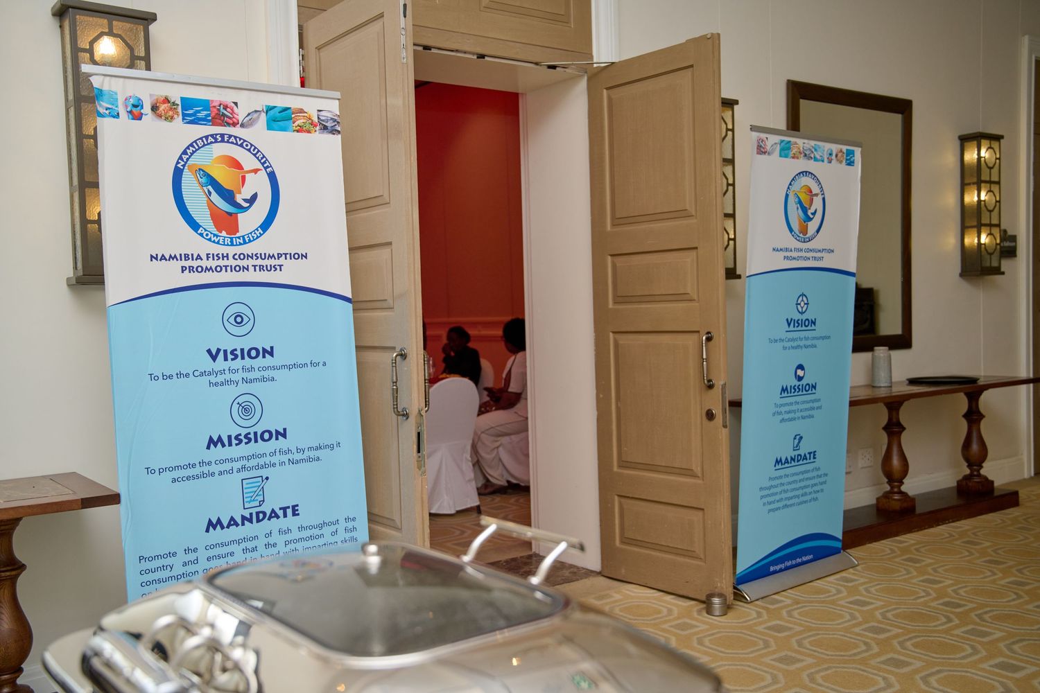Namibia Fish Consumption  promotion Trust event display with rollup banners showing Vision, Mission, and Mandate in a hall.