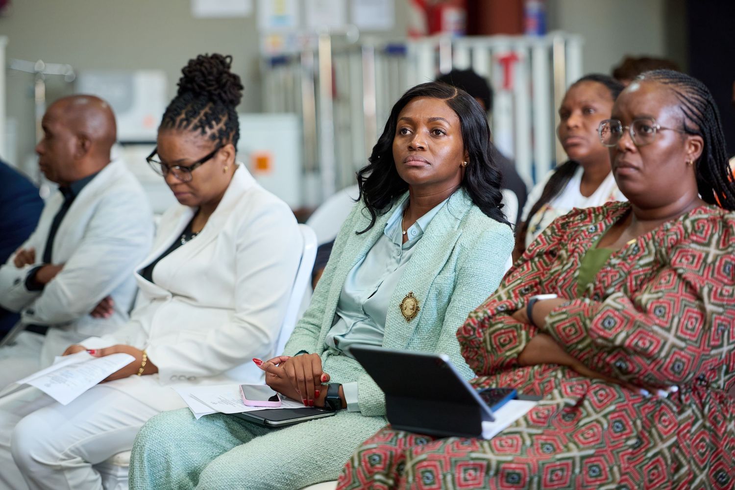 Group of African women attending a professional conference, one holding a laptop and papers.