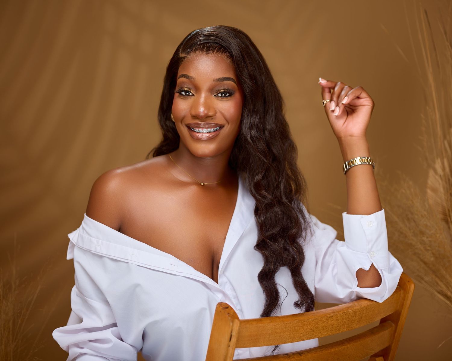 A series of professional studio portraits with gold background showing someone in a white off-shoulder top with dark hair.