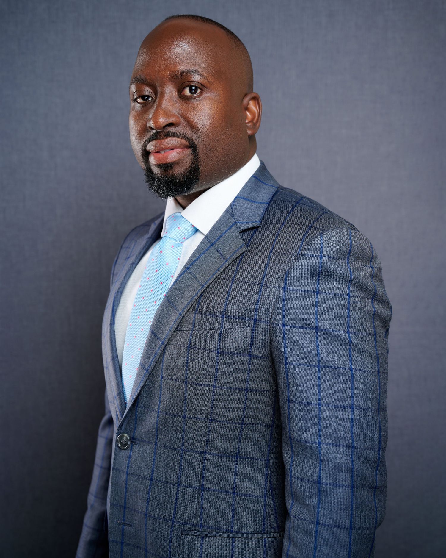 Professional headshot portrait series showing different angles of a person wearing a gray windowpane suit with light blue tie.