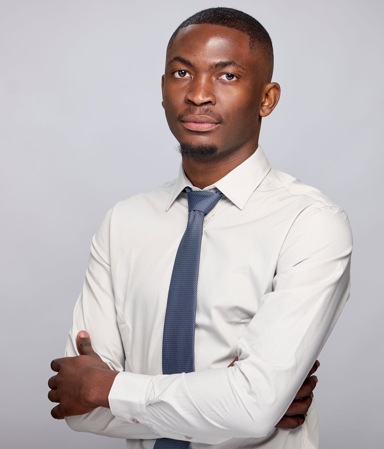 Professional portrait series showing confident poses in a white dress shirt and navy tie against a gray background.