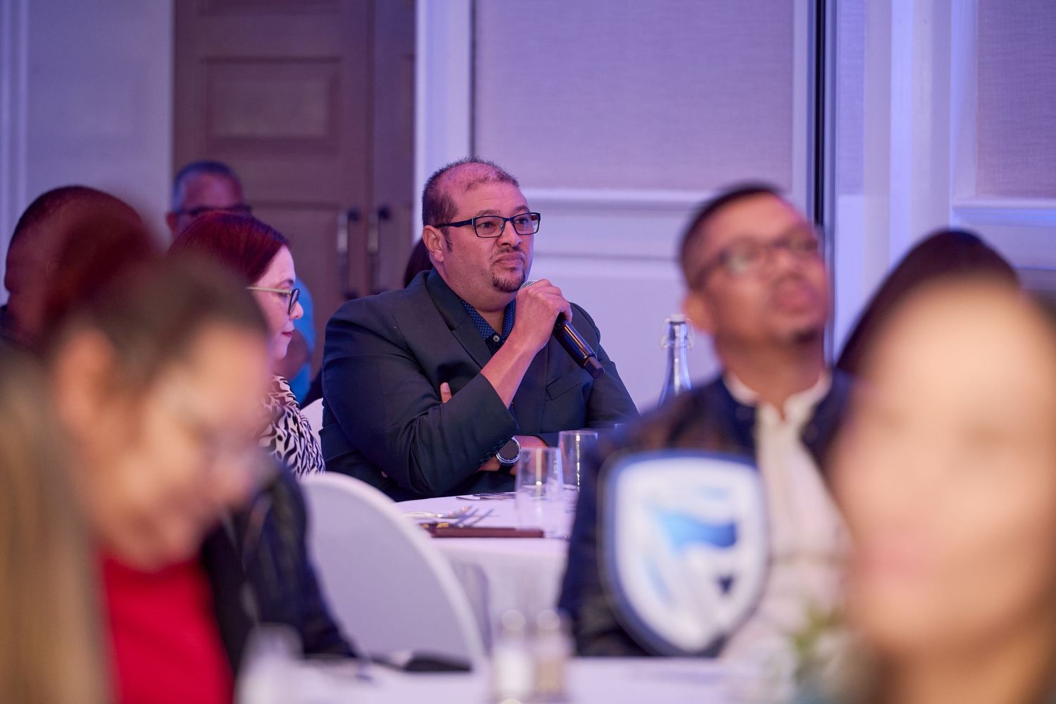 Audience members attentively listening at a professional conference or business seminar event.