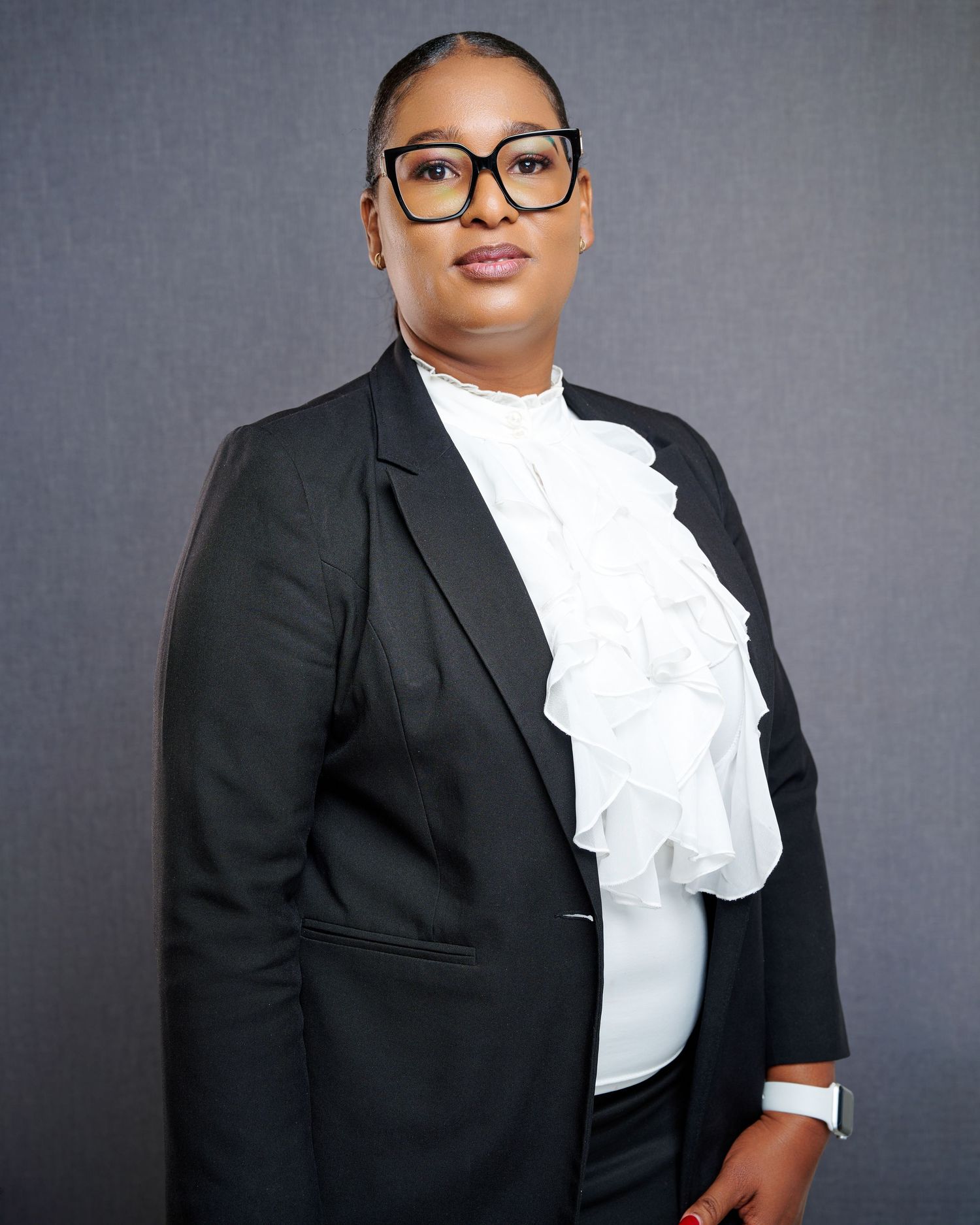 Professional portrait series showing a person in a black blazer and white ruffled blouse against a gray backdrop.