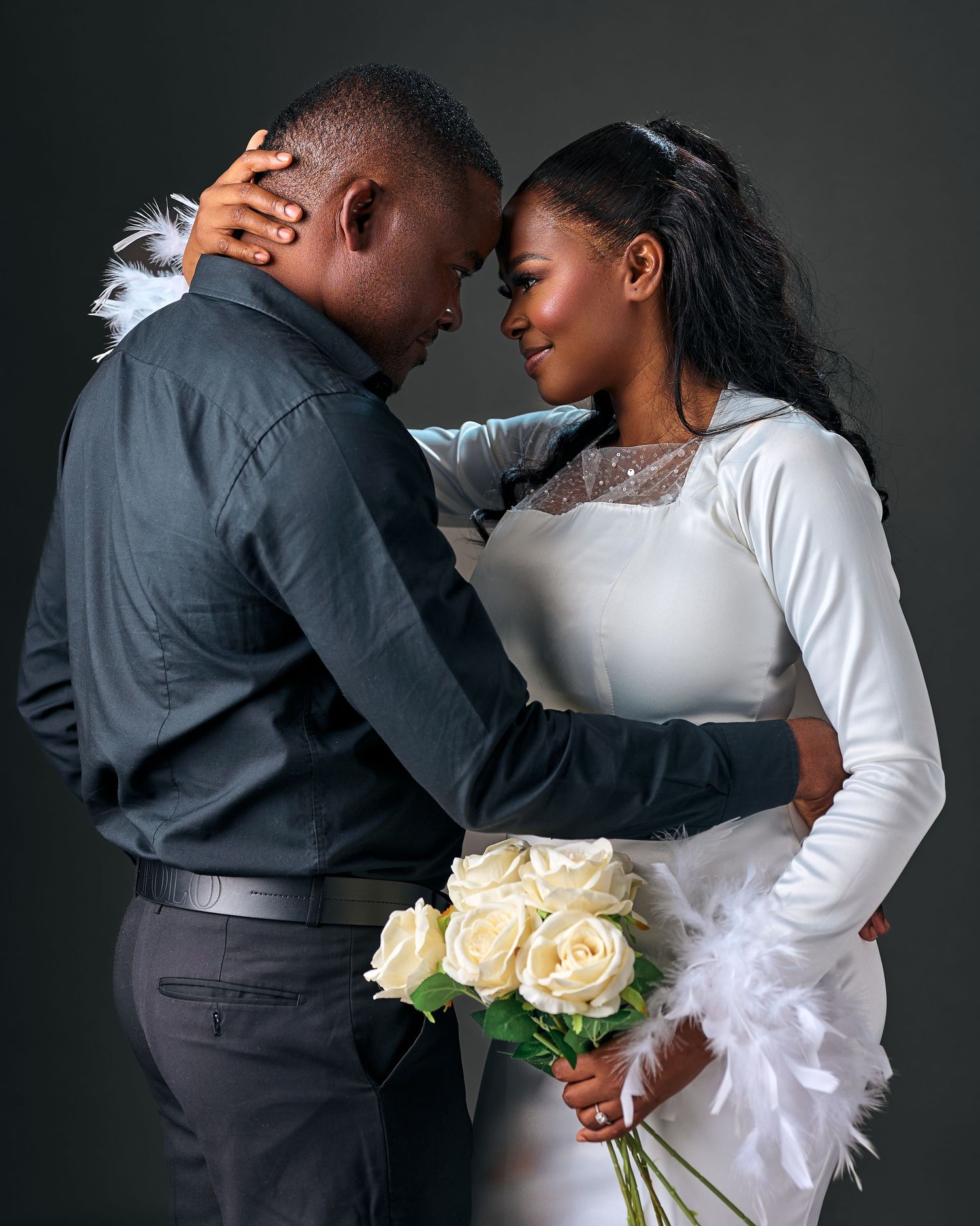 A romantic couple in formal attire sharing intimate moments in a series of black and white photographs with white roses.