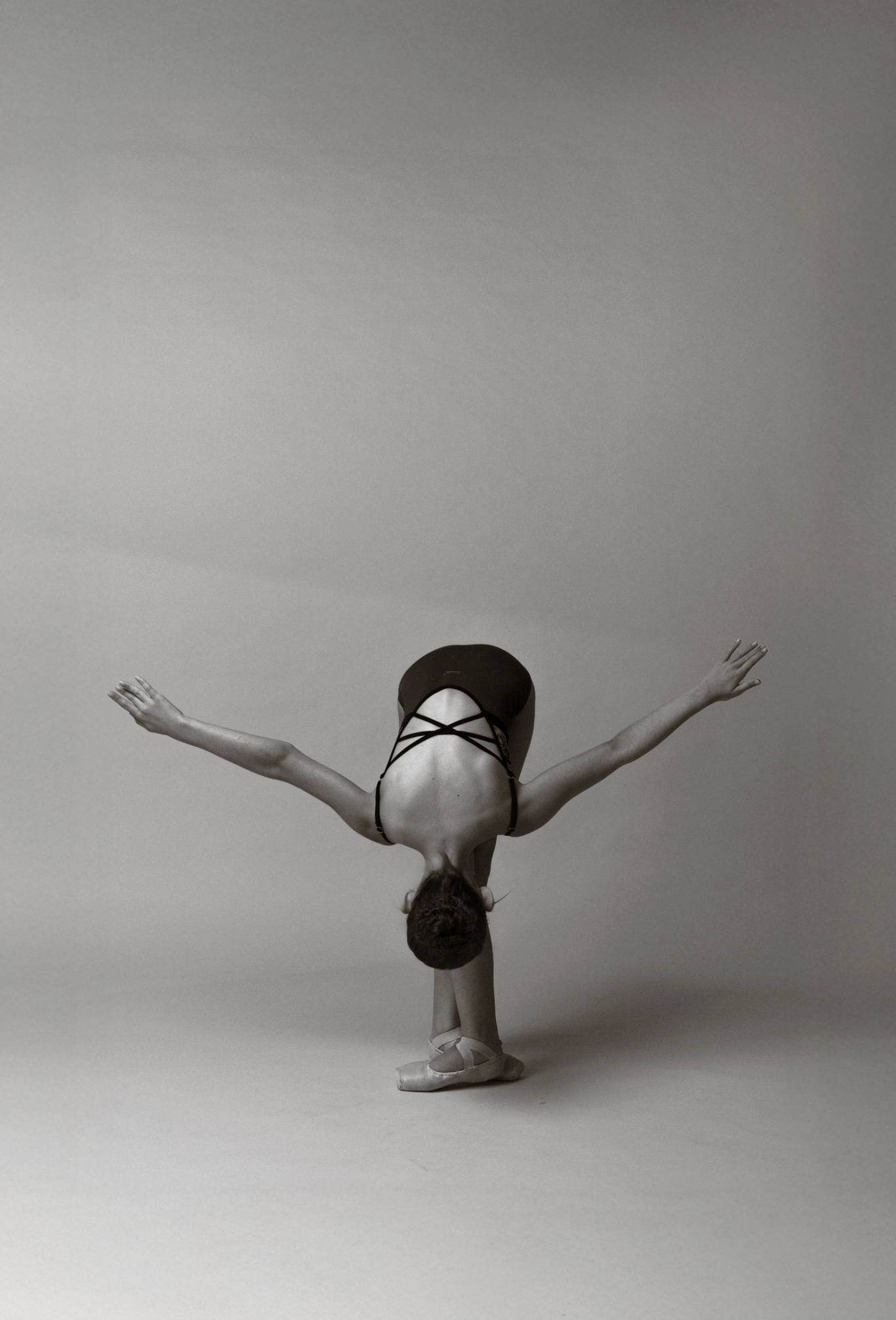 A black and white photo series showing a figure performing a graceful diving motion against a minimalist background.