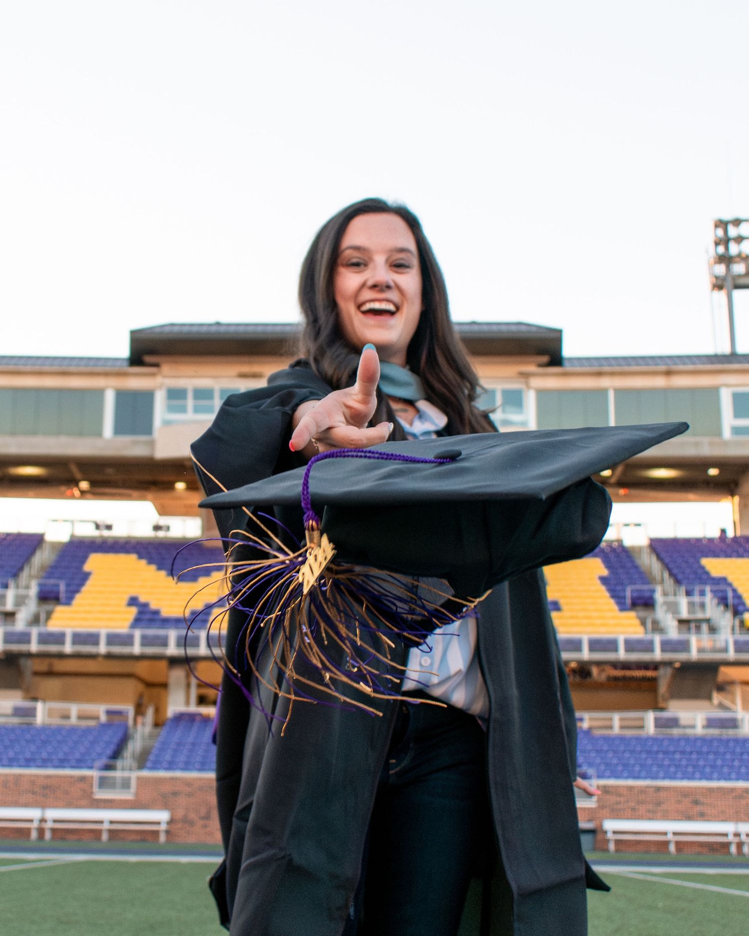 Graduate tossing cap at UMHB stadium in Belton Texas during senior session