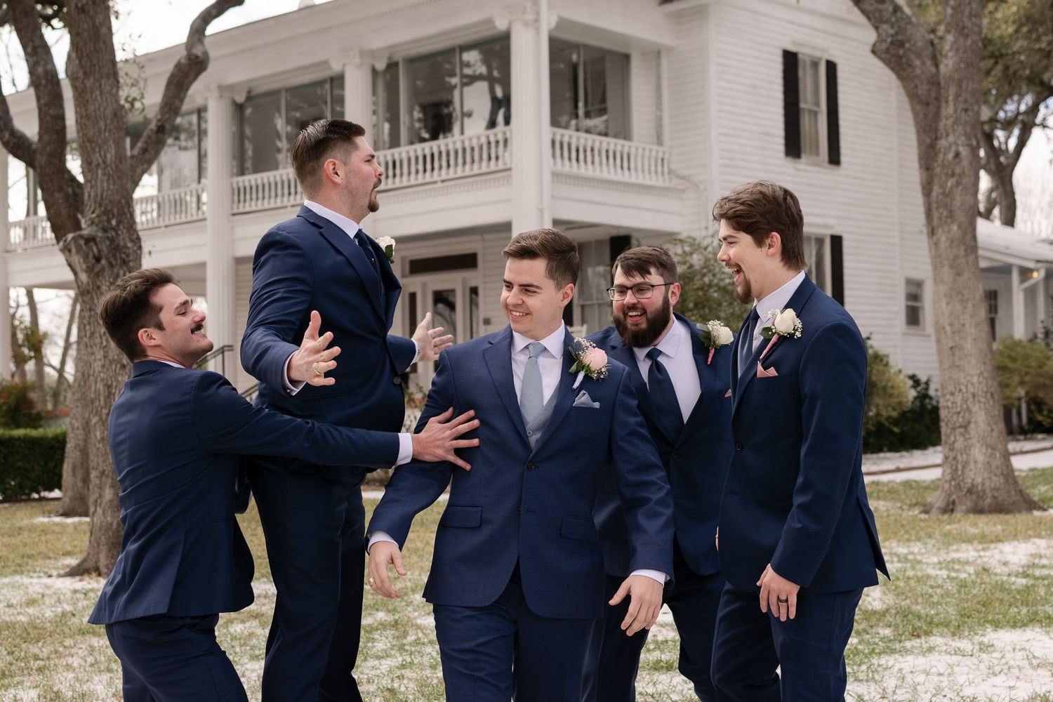 Groomsmen celebrating with groom outside Winfield Inn in Dripping Springs Texas.