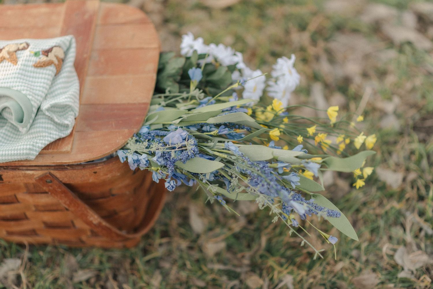 Basket with baby clothes and flowers during outdoor newborn session near Belton Texas