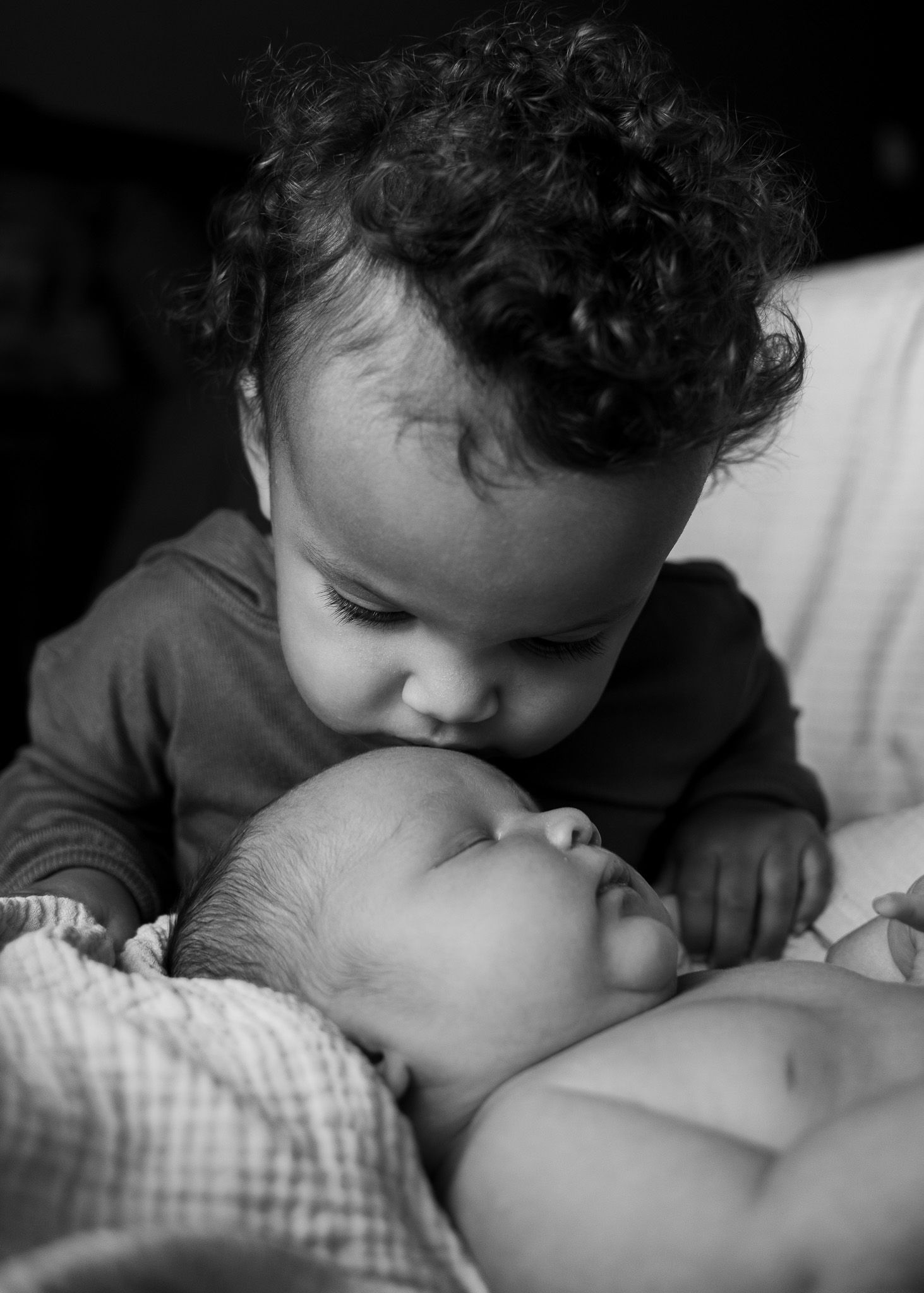 Big sister kissing newborn baby during session with a Belton Texas newborn photographer