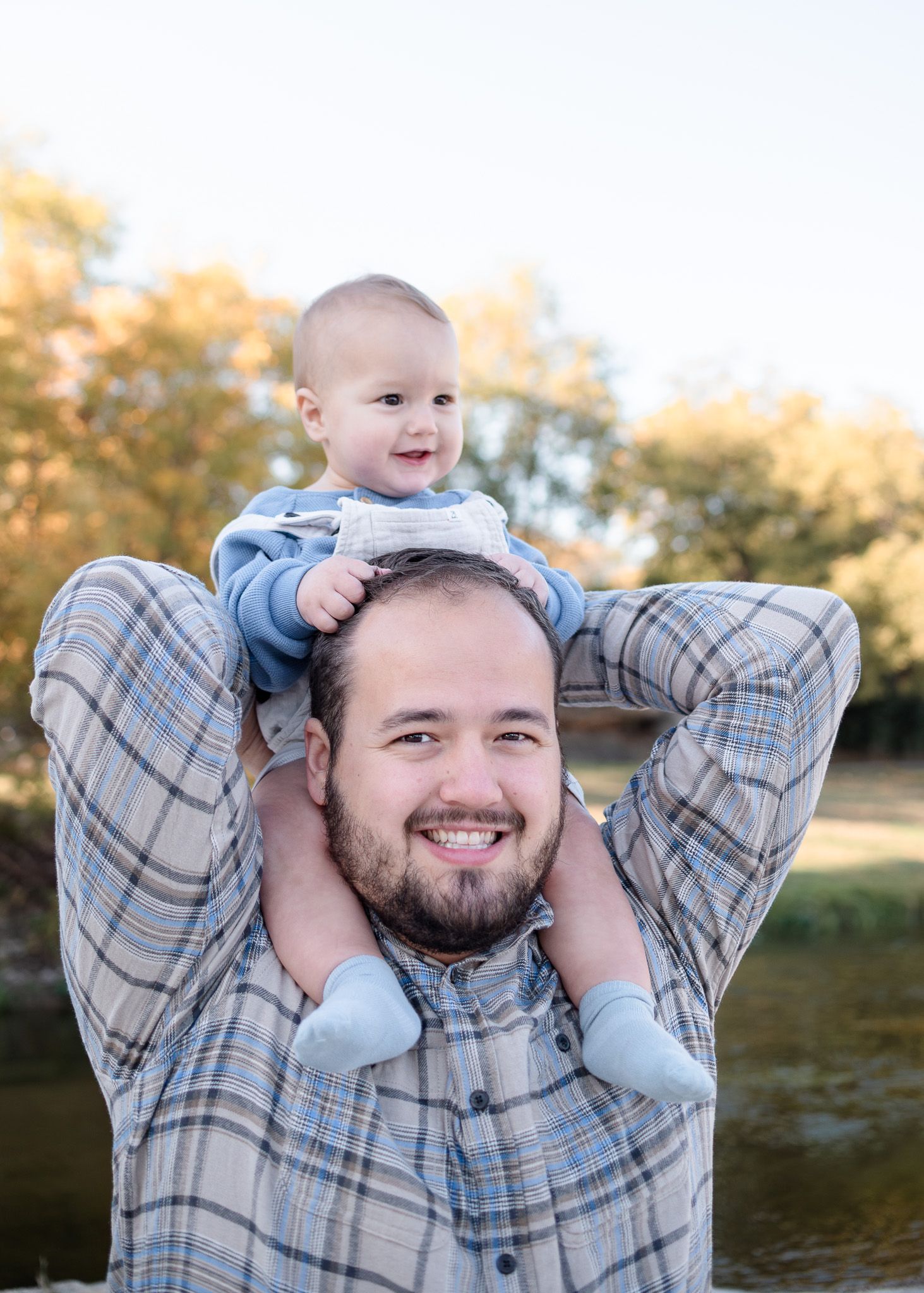 Father holding baby during outdoor family session at Nolan Creek in Belton Texas
